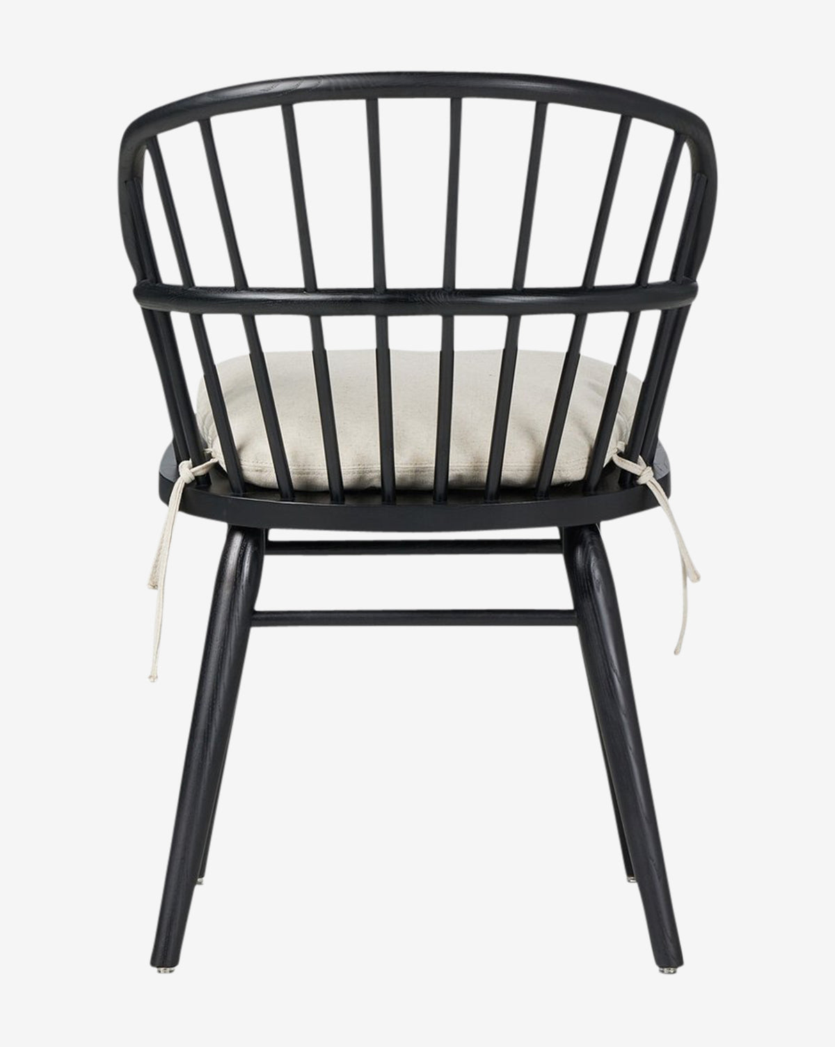 The Fiora Dining Chair features a black wooden frame with a rounded spindle-back design and a light beige removable cushion tied to the back, shown from the rear on a white background by McGee & Co.