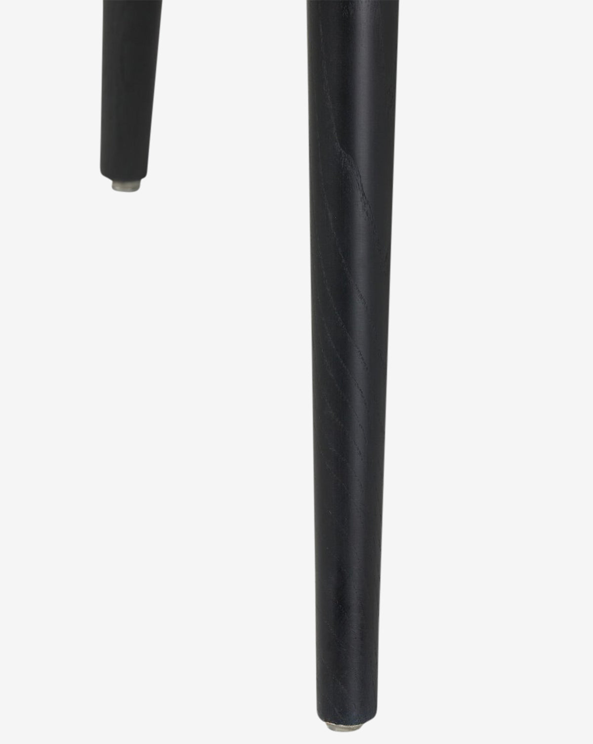 Close-up of two black, cylindrical, tapered legs from the Fiora Dining Chair, shown against a plain white background, by McGee & Co.