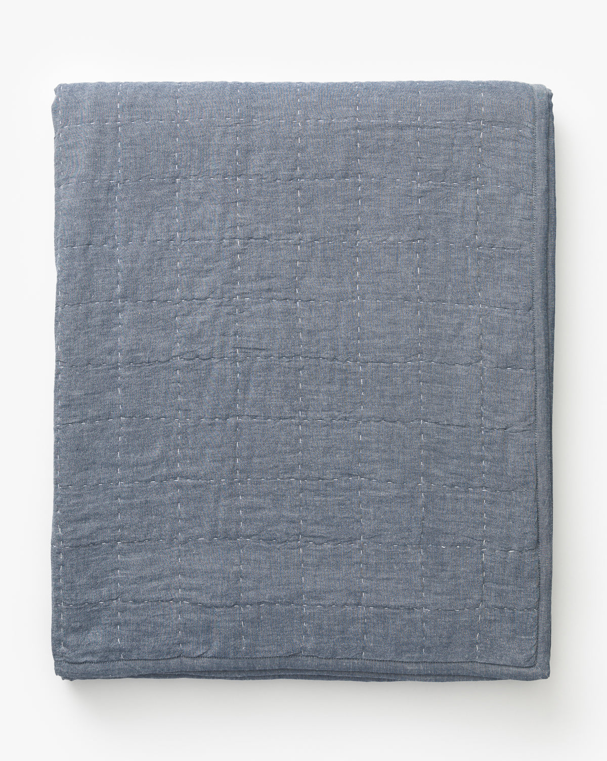 The Fitzgerald Kids Quilt, in blue-gray cotton with a subtle stitched grid pattern, is neatly folded and displayed on a white background.