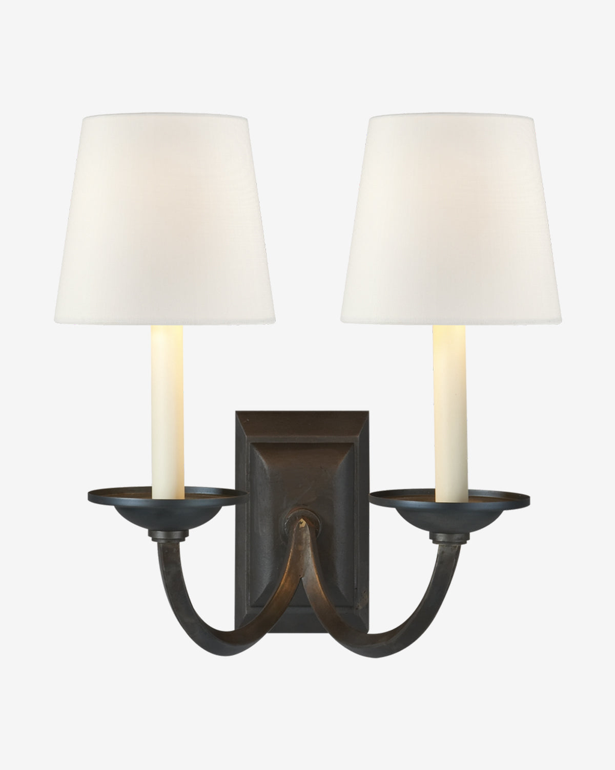 The Visual Comfort & Co. Signature Flemish Double Sconce features steel arms with two candle-style lights topped by white linen shades and is mounted on a dark metal base. McGee & Co.