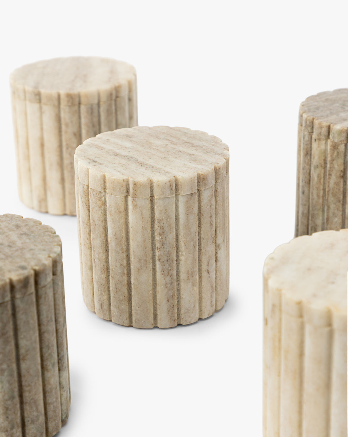 The Forster Marble Canister features a round, fluted design with a lid, crafted from beige organic marble. Its ribbed texture adds elegance to any decor, making it a stylish addition to your home.