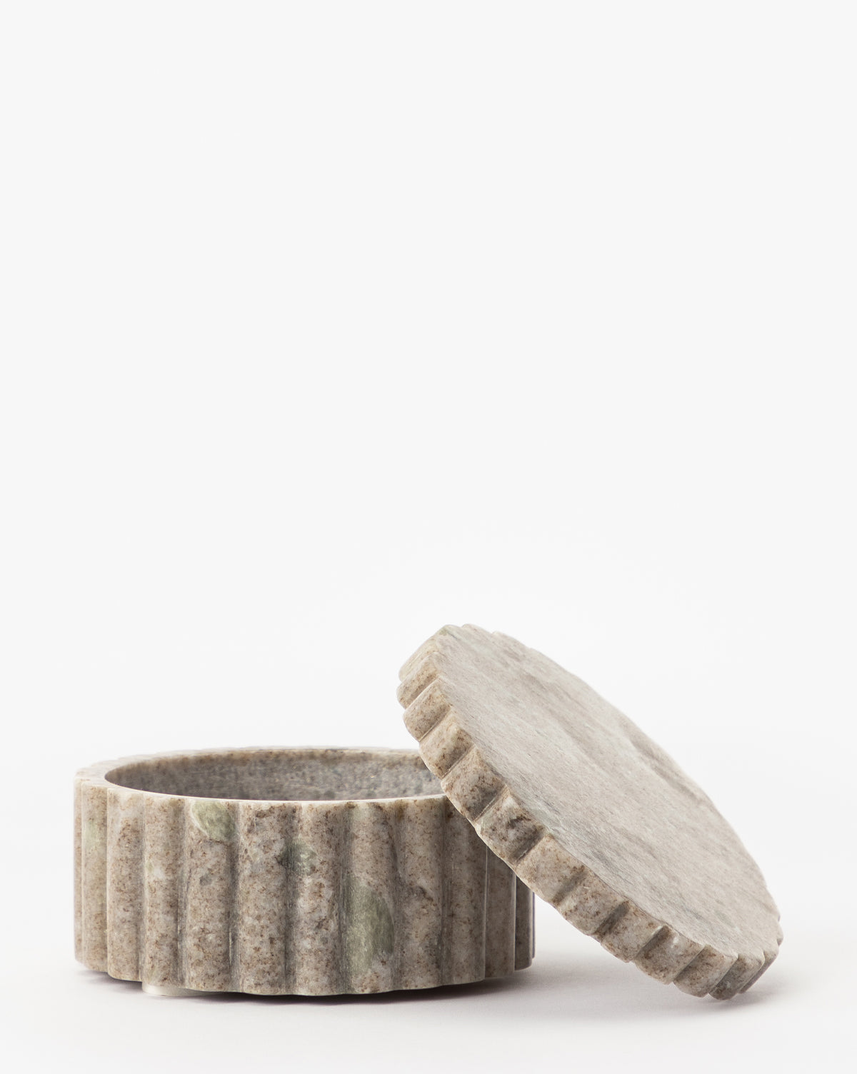 The Forster Marble Canister features a round, light gray design with vertical grooves and a matching lid. Its subtle greenish tones add elegant style to any space, making it a perfect home decor accent against a white background.