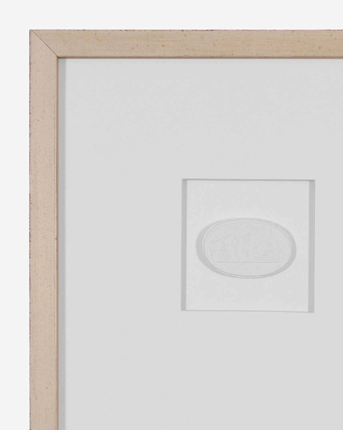 Framed Intaglio II features a small embossed oval design set in a light wood frame with a white mat. Its monochromatic art sits just right of the left edge, making it ideal for gallery wall decor.