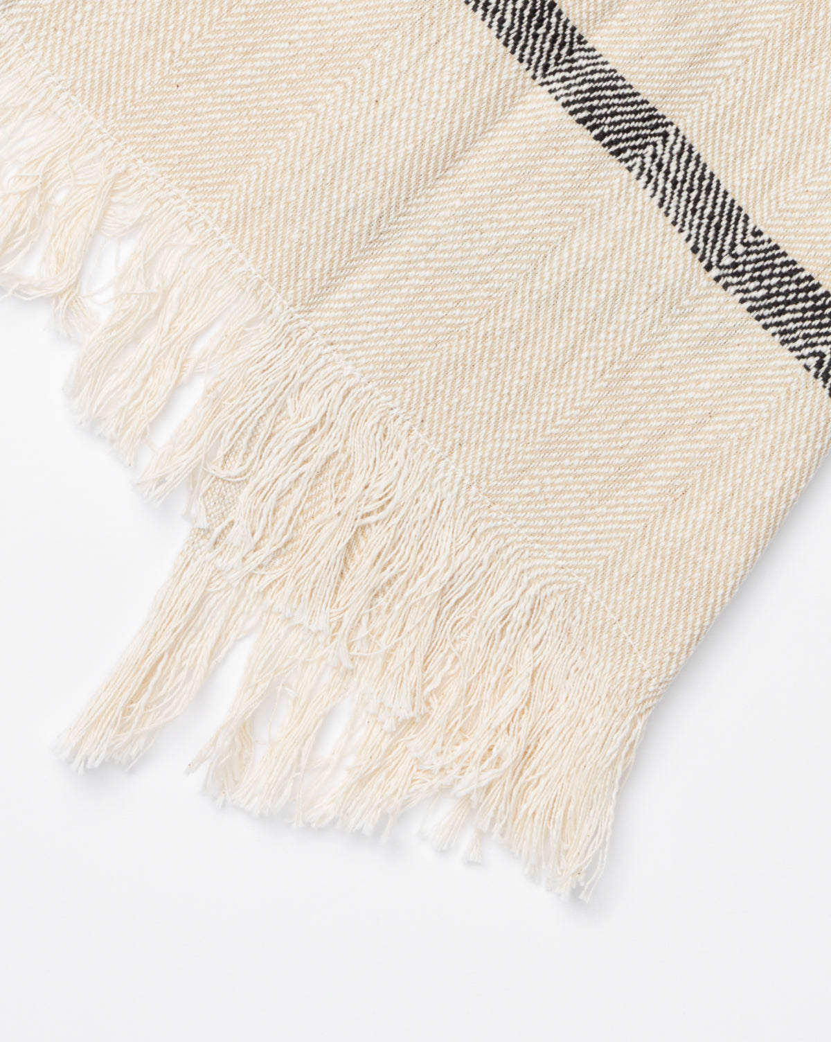 A close-up of the Fringed Striped Tea Towel (Set of 2) shows its beige color, subtle chevron pattern, fringed edges, and a single black stripe—an elegant accent for any kitchen décor, by McGee & Co.