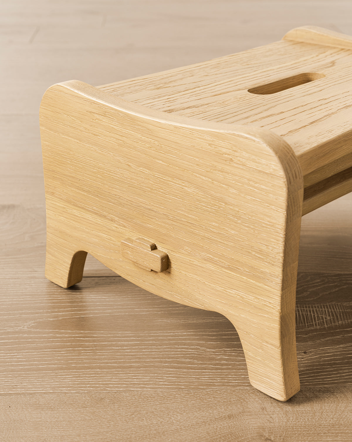 The Gable Step Stool by YANG CHENG WOODEN INDUSTRIES INTERNATIONAL (VIETNAM) CO LTD, featuring mortise and tenon joinery, curved edges, and a top handle slot, sits gracefully on a wooden floor by McGee & Co.