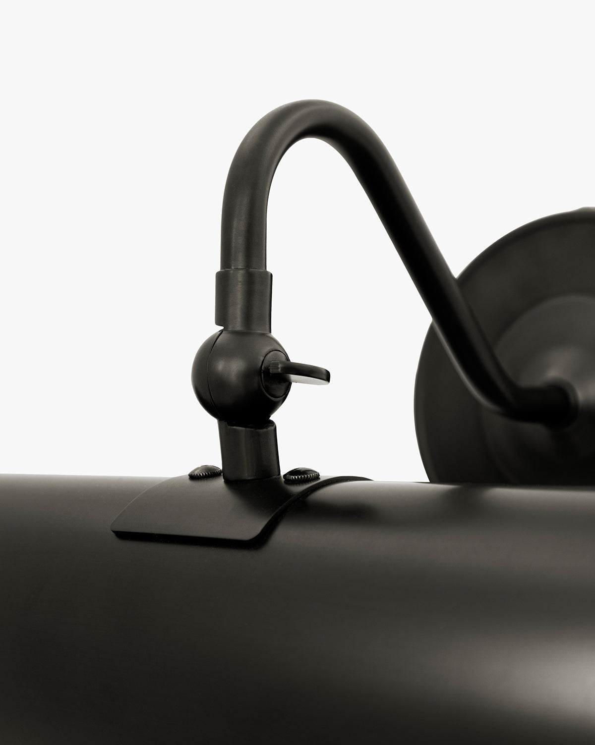 Close-up of the Gallery Picture Sconce, a vintage-inspired matte black wall-mounted lamp with an adjustable curved arm and cylindrical shade, detailed hardware and screws, set against a plain white background, by McGee & Co.