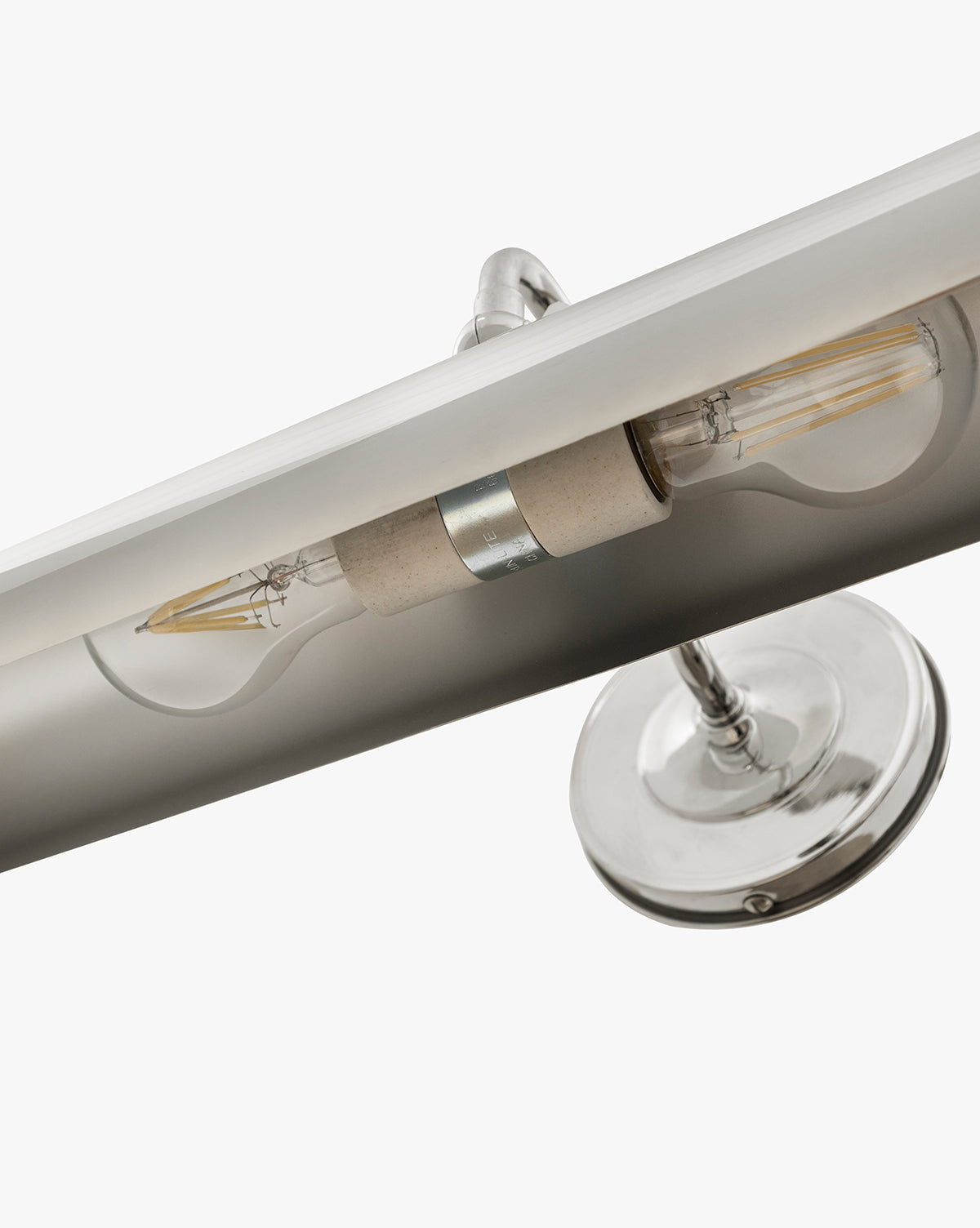 Close-up of the Gallery Picture Sconce with a burnished bronze metallic base and two exposed filament bulbs, shown against a plain white background, by McGee & Co.