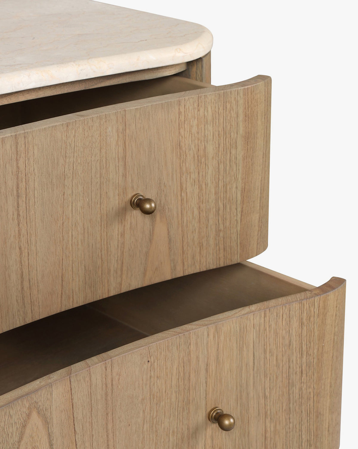 A close-up of the Gatlin Chest reveals its spacious drawers, light mindi wood finish, round brass knobs, and a smooth marble top, by McGee & Co.