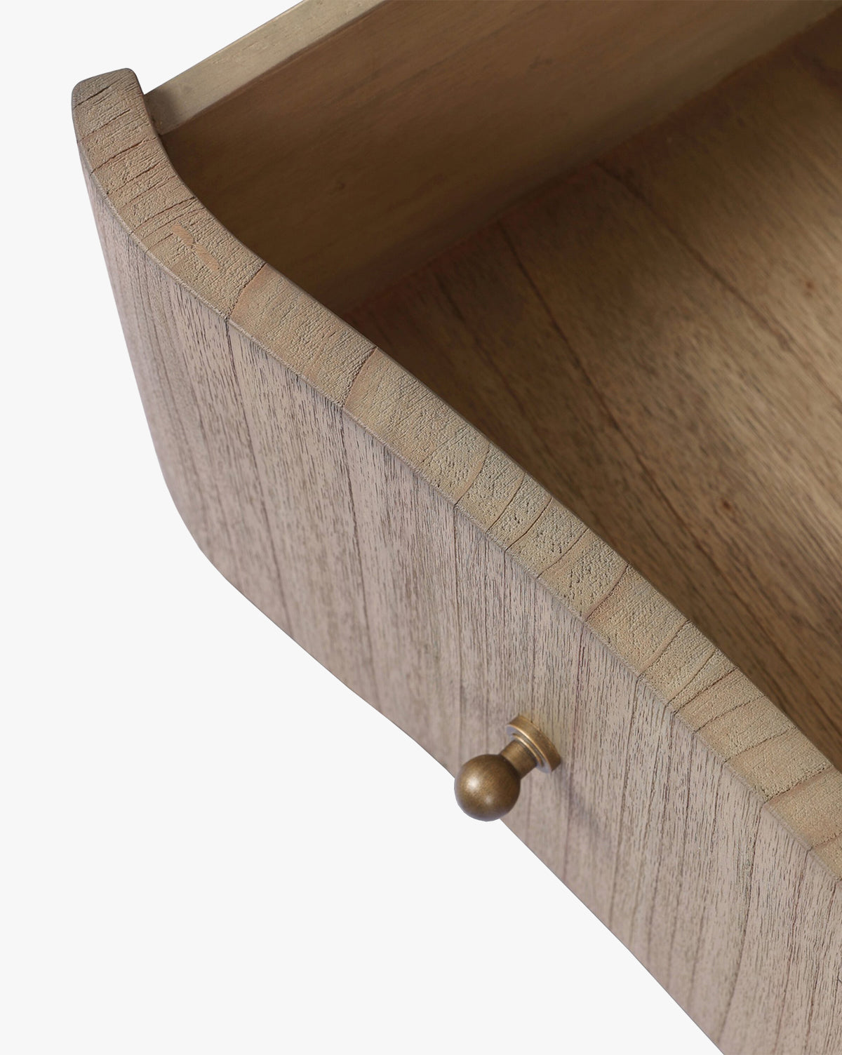 A close-up of an open drawer from the Gatlin Chest highlights its spacious, empty interior, solid mindi wood grain, and a small round brass knob by McGee & Co.
