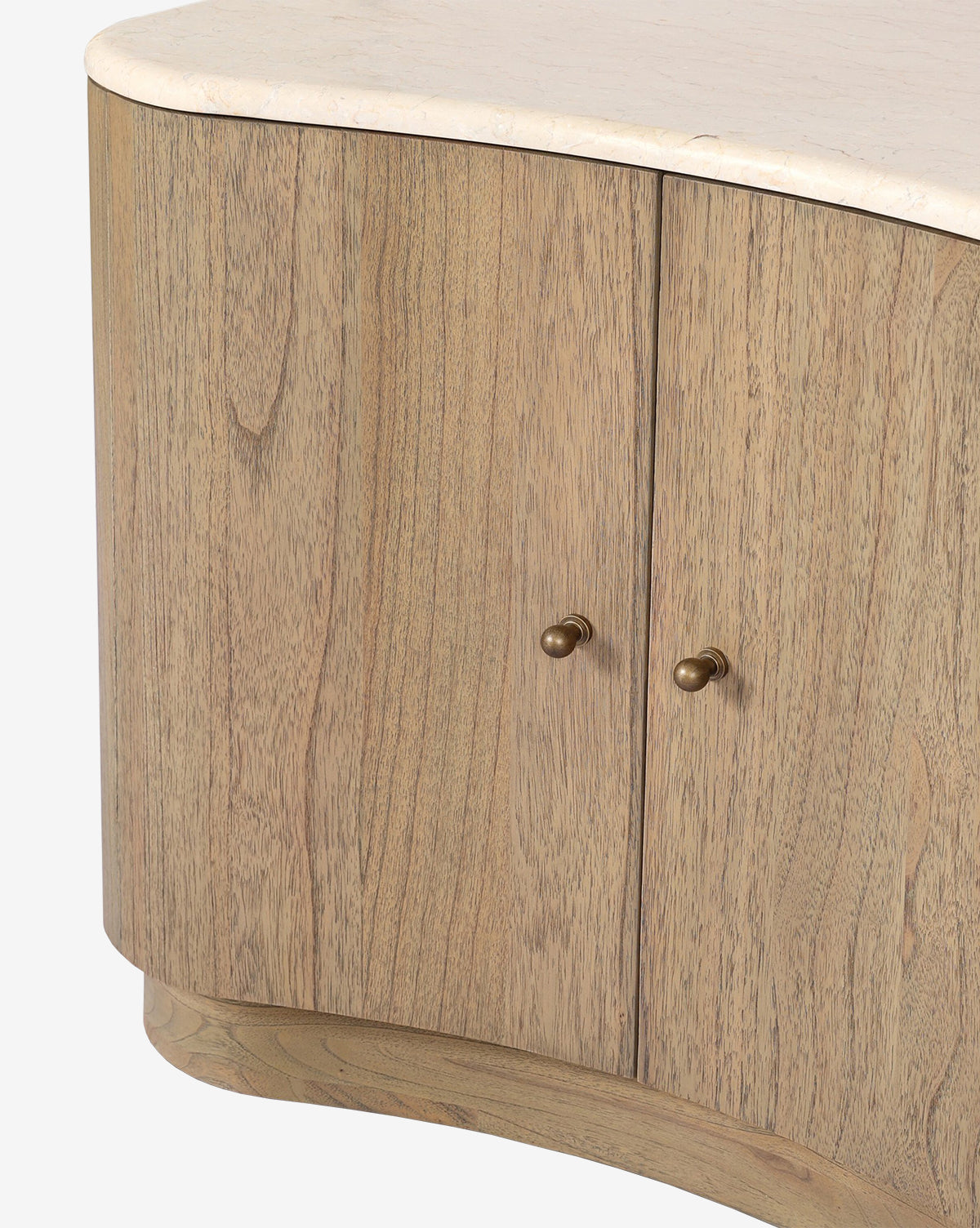 The Gatlin Nightstand, made from solid mindi wood with a light natural finish, features two doors with round brass knobs, a light stone top, and offers ample bedside storage, by McGee & Co.