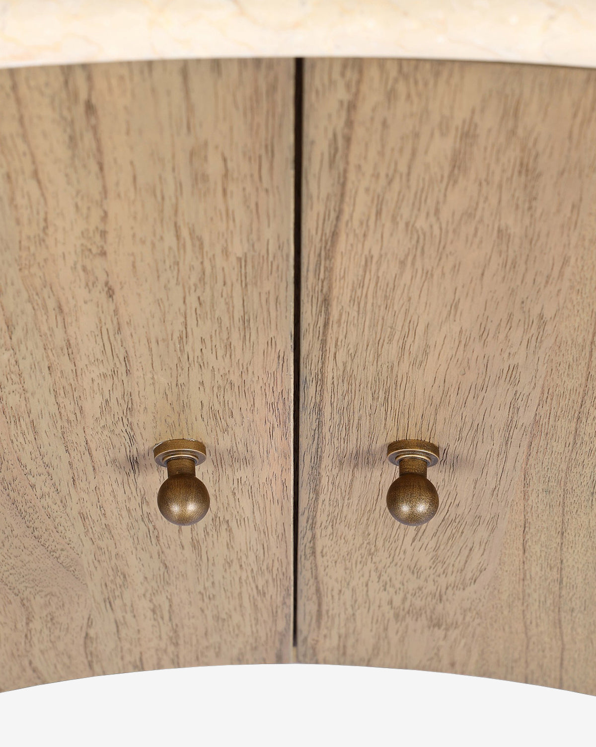 Close-up of the Gatlin Nightstand’s two solid mindi wood cabinet doors, detailed with round brass knobs, a vertical seam, and a natural finish that highlights the wood grain—ideal for elegant bedside storage, by McGee & Co.