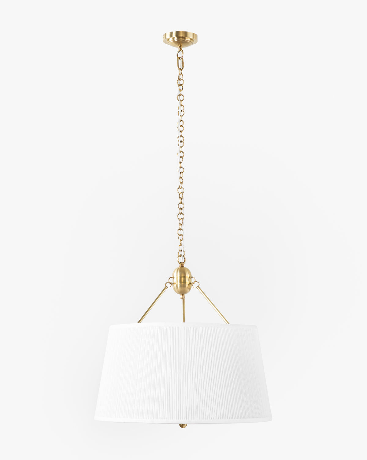 The Georgiana Pendant showcases an antique brass finish and a white linen pleated shade, hanging from a decorative brass chain, by McGee & Co.