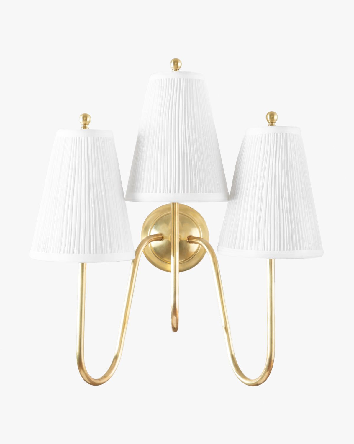 The Makerspalm Georgiana Triple Sconce showcases an antique brass finish with three curved arms and elegant linen pleated shades, all set against a plain white background. McGee & Co.