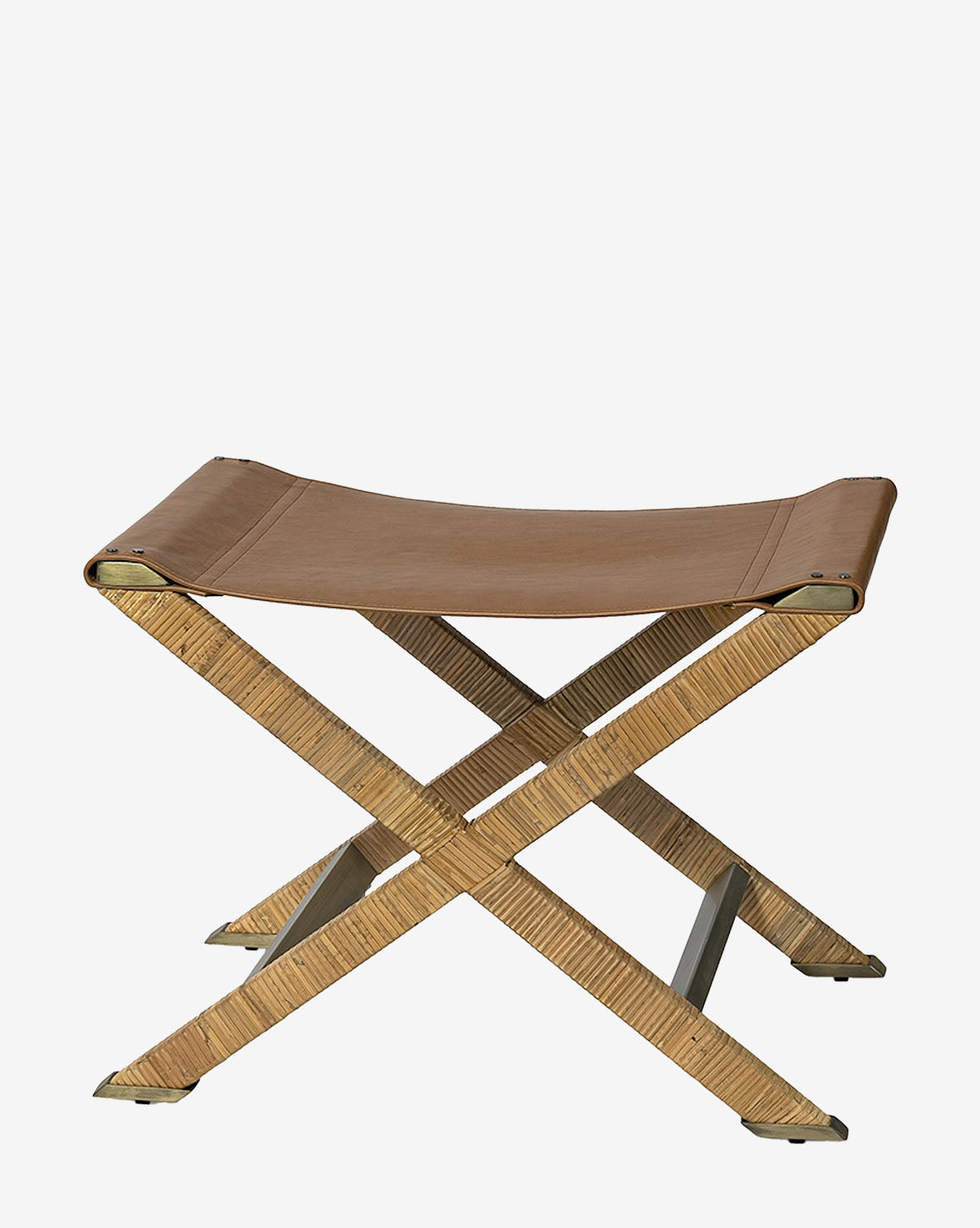 The Palecek Gertie Stool showcases a tan leather seat and light wood X-shaped legs, offering a stylish and functional accent piece against a plain white background. McGee & Co.