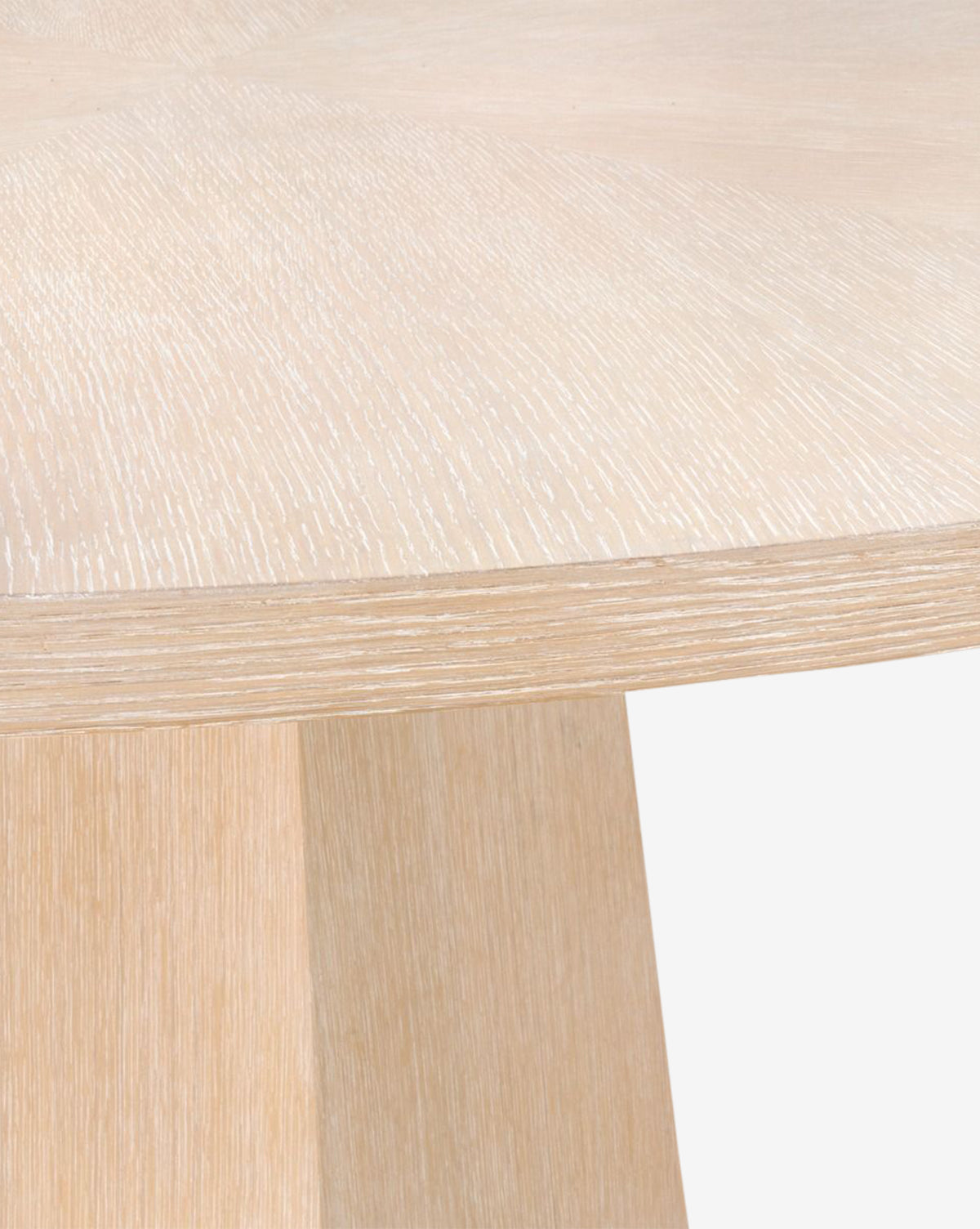 Close-up of the Gideon Dining Table, featuring a smooth light oak surface and visible wood grain, highlighting the tabletop and base edge against a plain white background by McGee & Co.