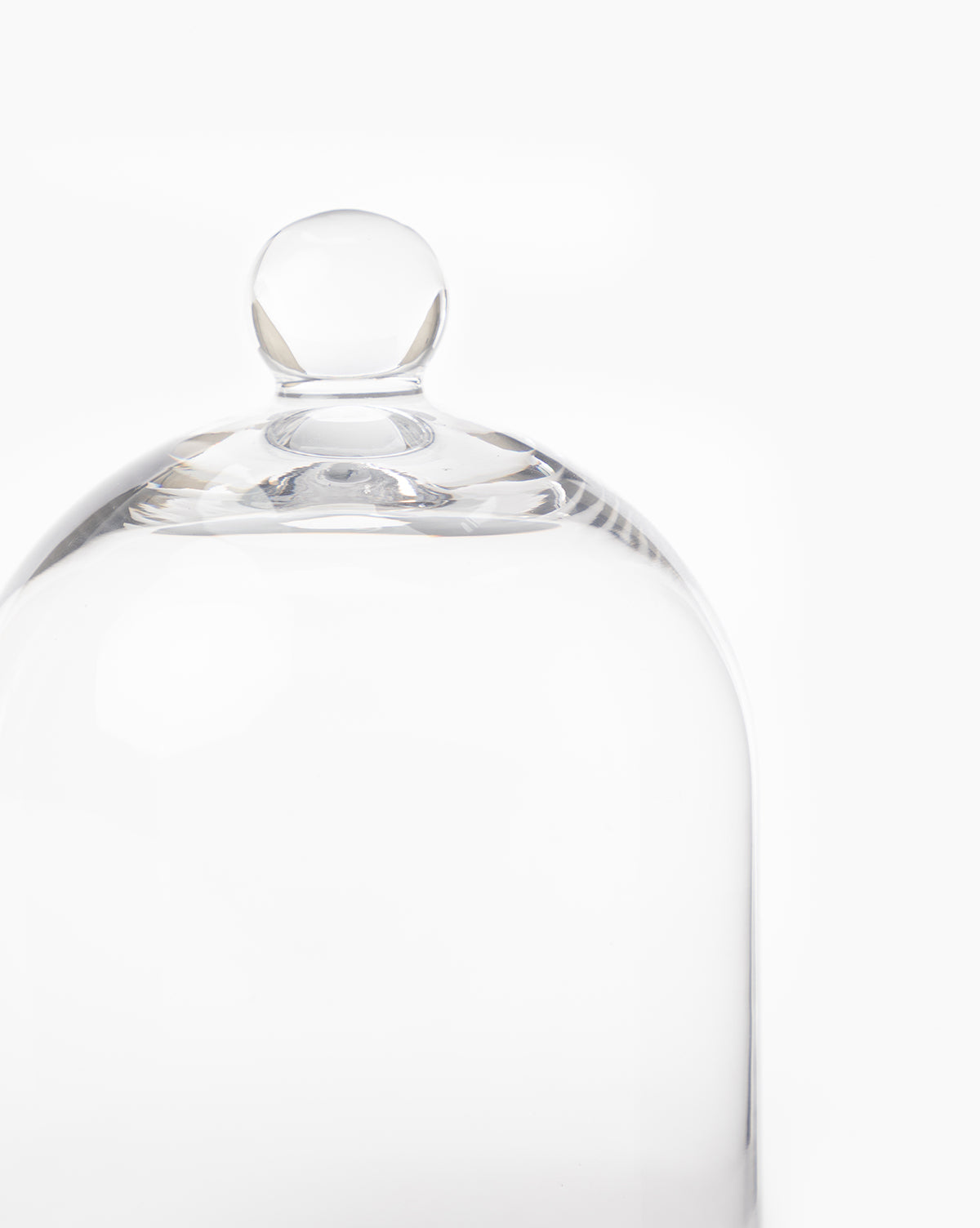 The Glass Cloche features a clear dome with a round knob, ideal for displaying baked goods or adding elegant charm to your kitchen décor. Shown against a plain white background.