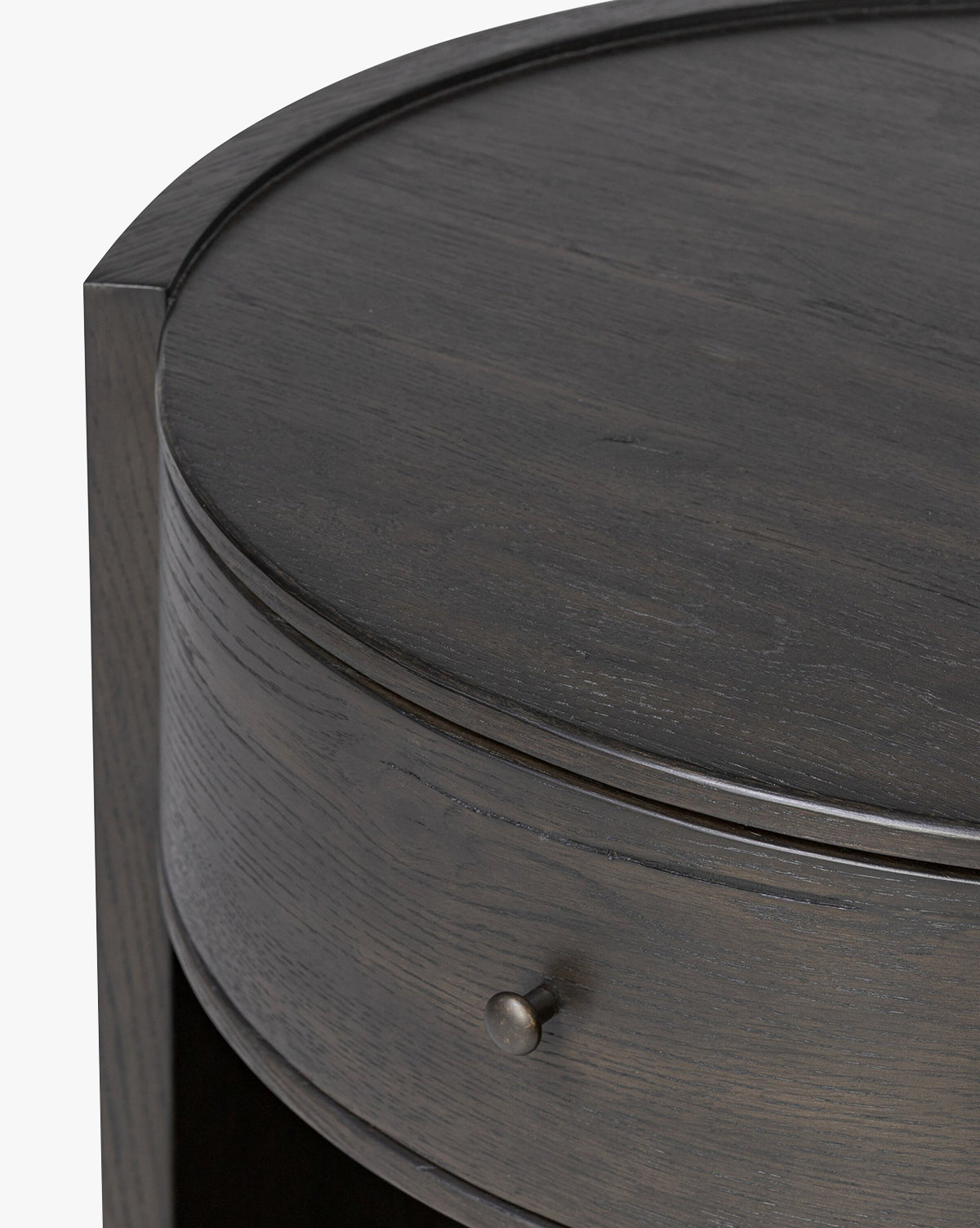 Close-up of the Glenndon Oak Nightstand featuring a black finish, visible wood grain, a single metal drawer knob, and smooth curved edges, by McGee & Co.