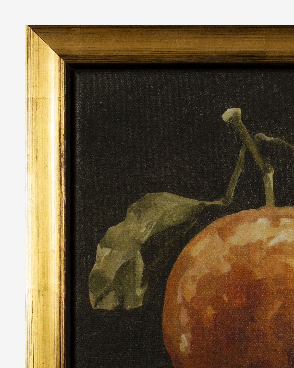 A close-up, moody still life of Gloomy Clementine I—a framed print featuring part of an orange fruit with a green leaf against a dark background in a gold, wood-textured frame.