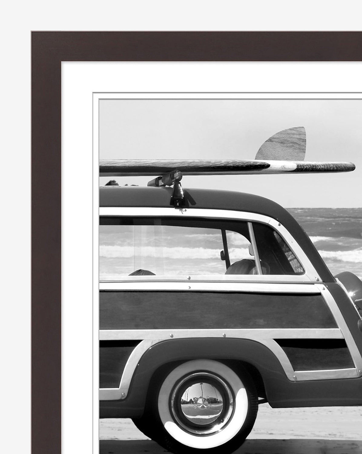 Gone Surfin wall art features a vintage station wagon with a surfboard atop, parked on the beach with the ocean in the background, all elegantly framed with a wide mat—an ideal piece of coastal cool home decor.