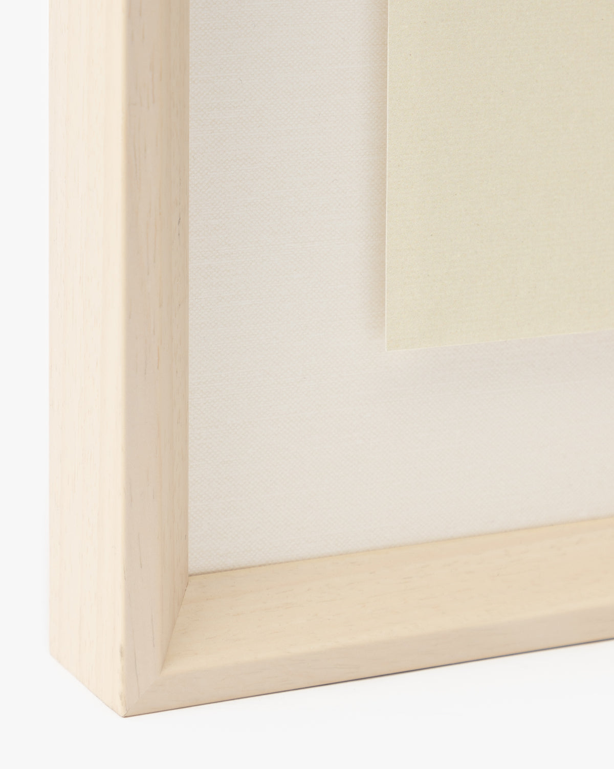Close-up of a light wood picture frame with a white mat, showcasing the Grape Collage giclee print, featuring beige paper inside the frame against a plain background, by McGee & Co.