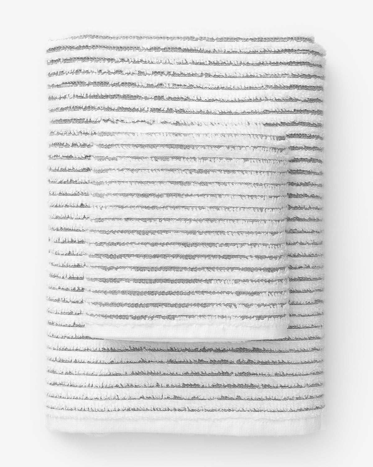 Neatly stacked against a white background, the Gray Striped Bath Collection features folded white Aegean cotton towels and washcloths with thin, evenly spaced gray stripes—luxurious essentials for any bathroom.