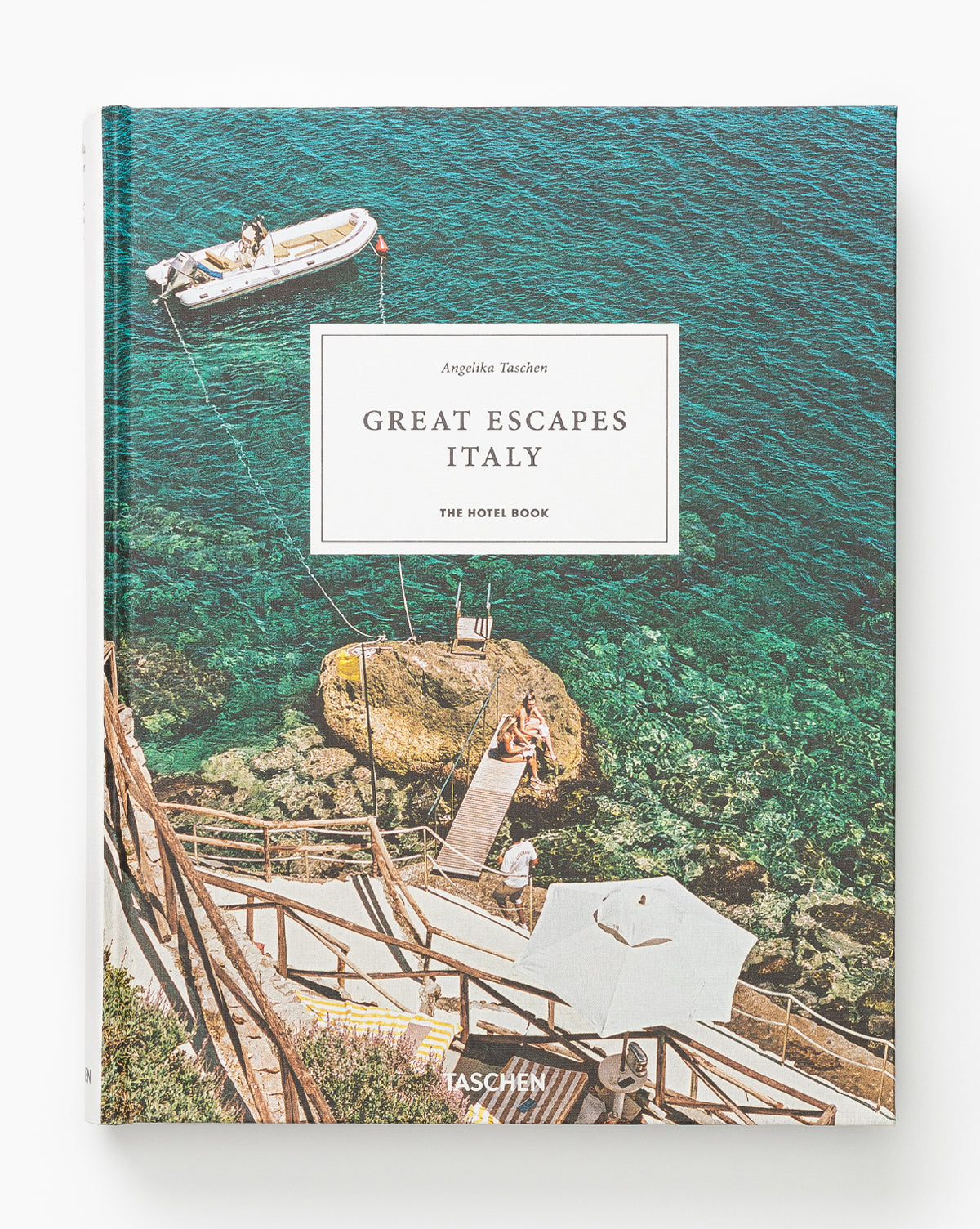 Book cover shows clear turquoise water, a small boat, swimmers, and a dock with stairs to a rocky shore. The title “Great Escapes Italy” highlights beautiful Italian hotels curated by Angelika Taschen.