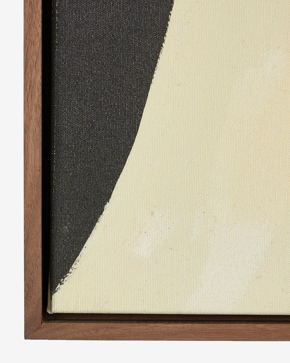 A close-up of Grecco I by Jess Engle, a framed abstract painting with a curved black shape on a light cream background, featuring a walnut gallery floater frame along the left and bottom edges for a modern accent, by McGee & Co.