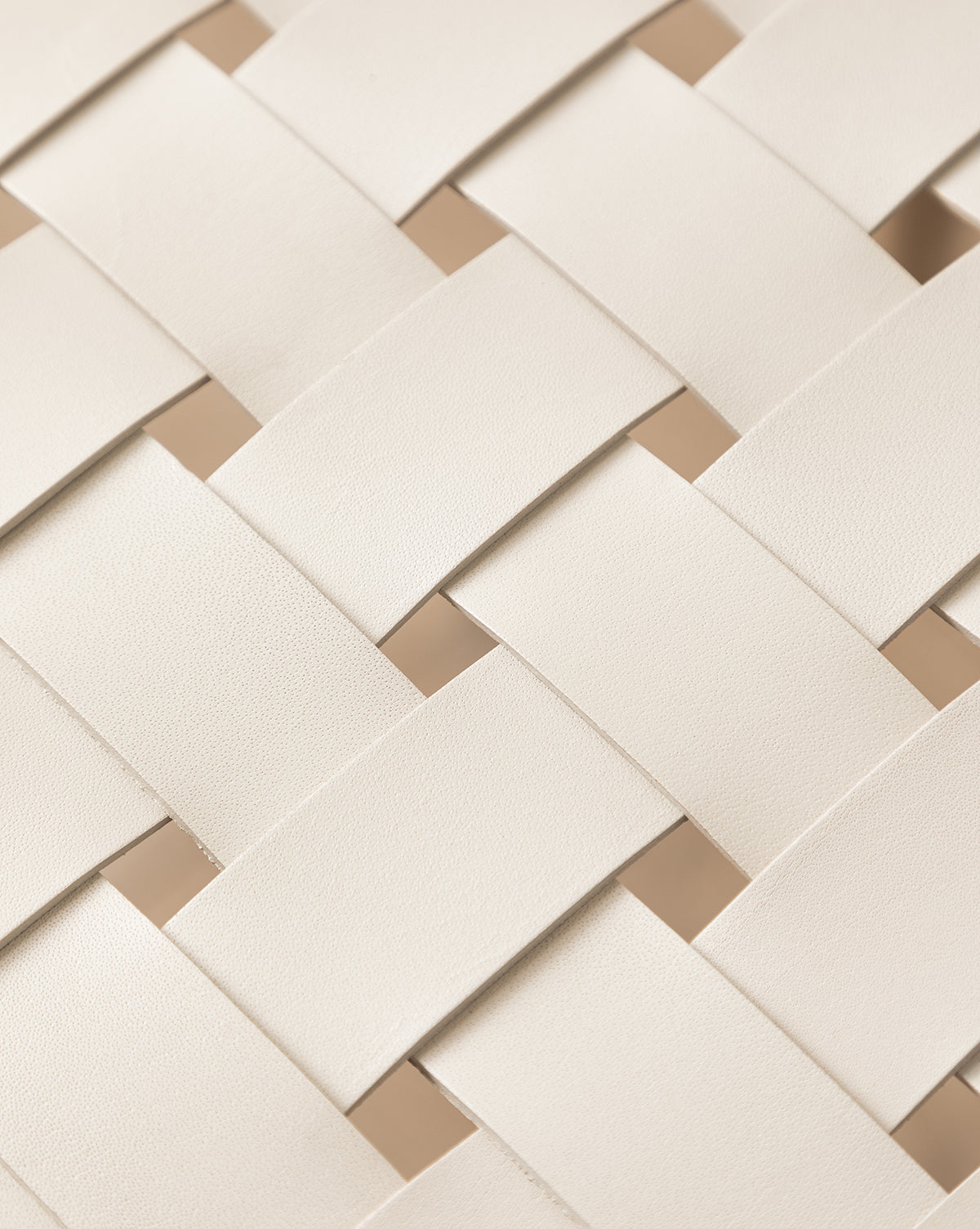 Close-up of the Greely Stool’s overlapping, crisscross pattern crafted from wide, cream aniline-dyed leather strips. The smooth, subtly textured finish showcases the luxury of this high-end woven counter stool by McGee & Co.