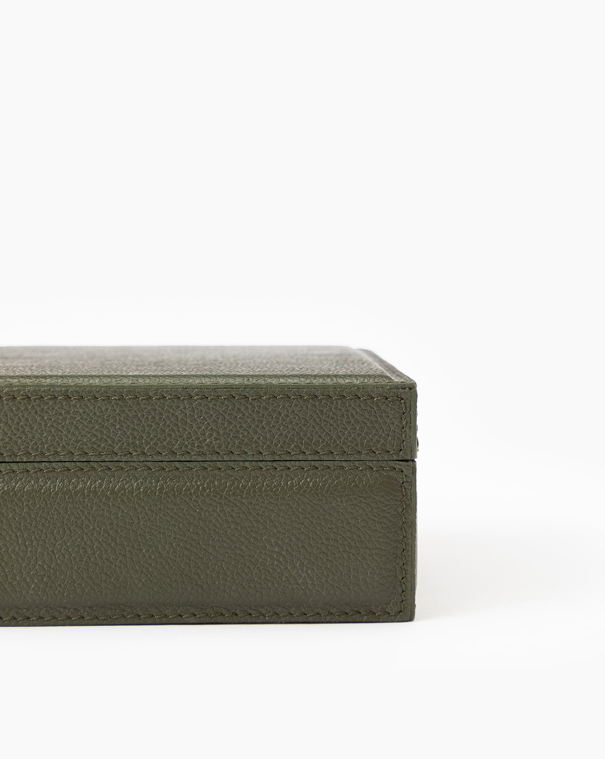 Close-up of the corner of the Green Leather Box, a textured rectangular storage box with a hinged lid, shown against a plain white background.