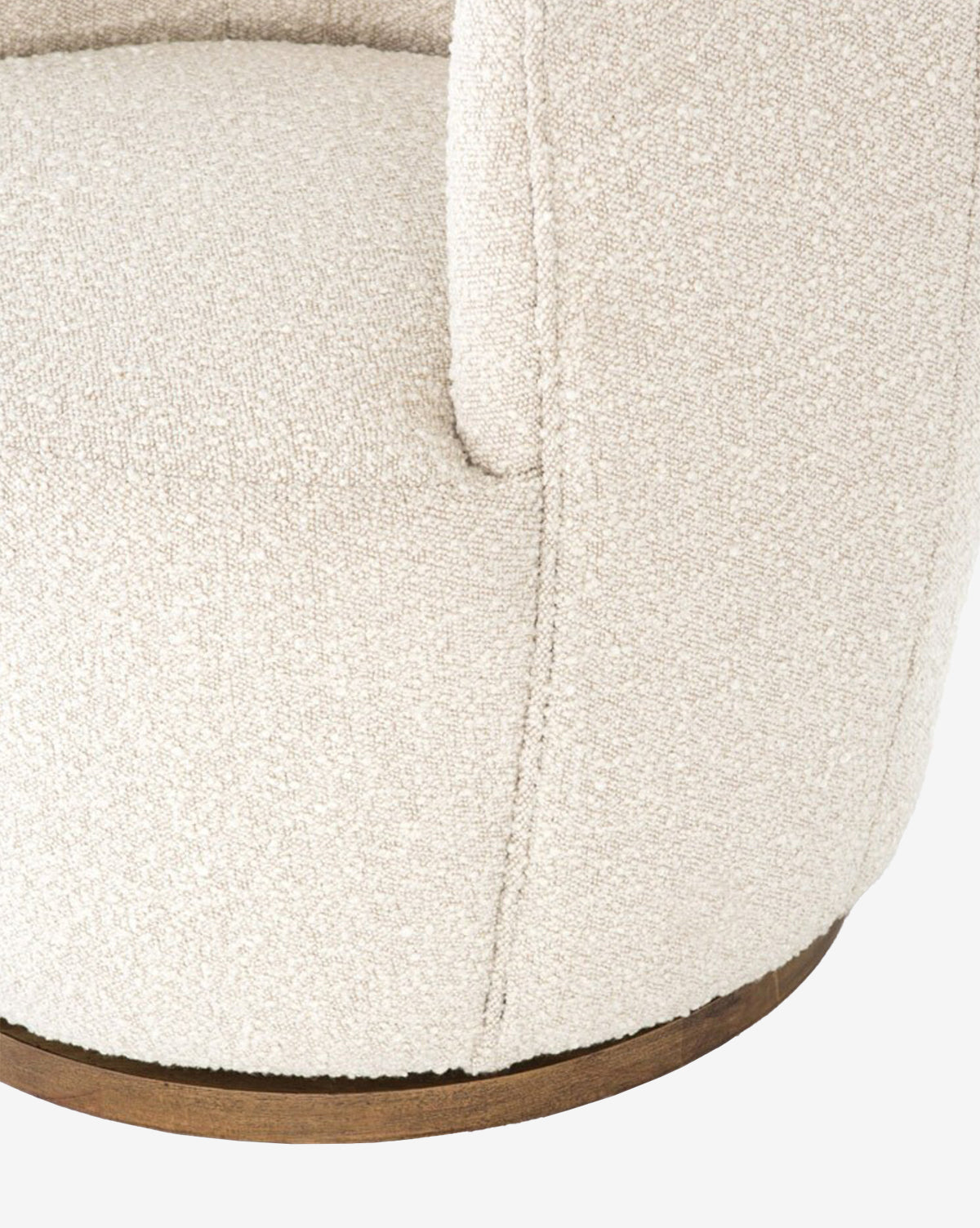 Close-up of the Gulliver Swivel Chair, a modern piece featuring textured cream boucle fabric, visible seam details, and a round wooden base.