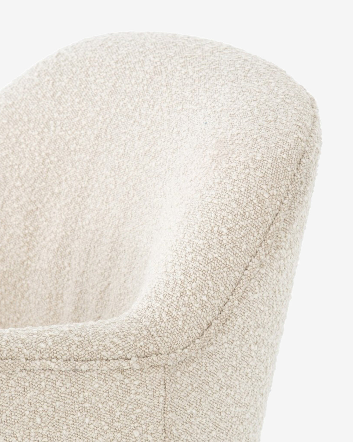 A close-up of the Gulliver Swivel Chair’s upper back and curved armrest, showing its modern, off-white boucle upholstery against a plain white background.