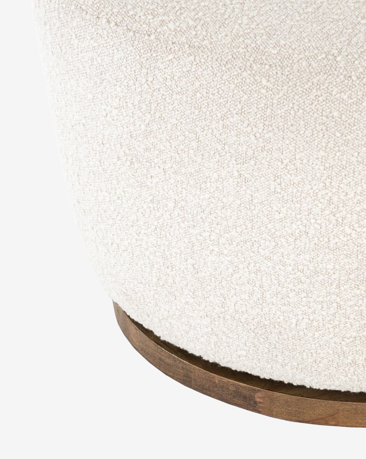Close-up of the lower part of the Gulliver Swivel Chair, featuring textured off-white boucle fabric and a contemporary wooden base.