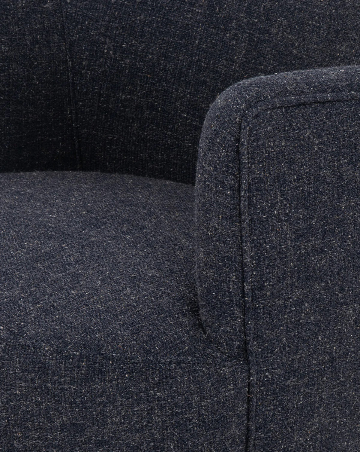 Close-up of the Gulliver Swivel Chair in dark blue, showcasing its textured boucle fabric and rounded, cushioned seat and armrest for a stylish, contemporary look.