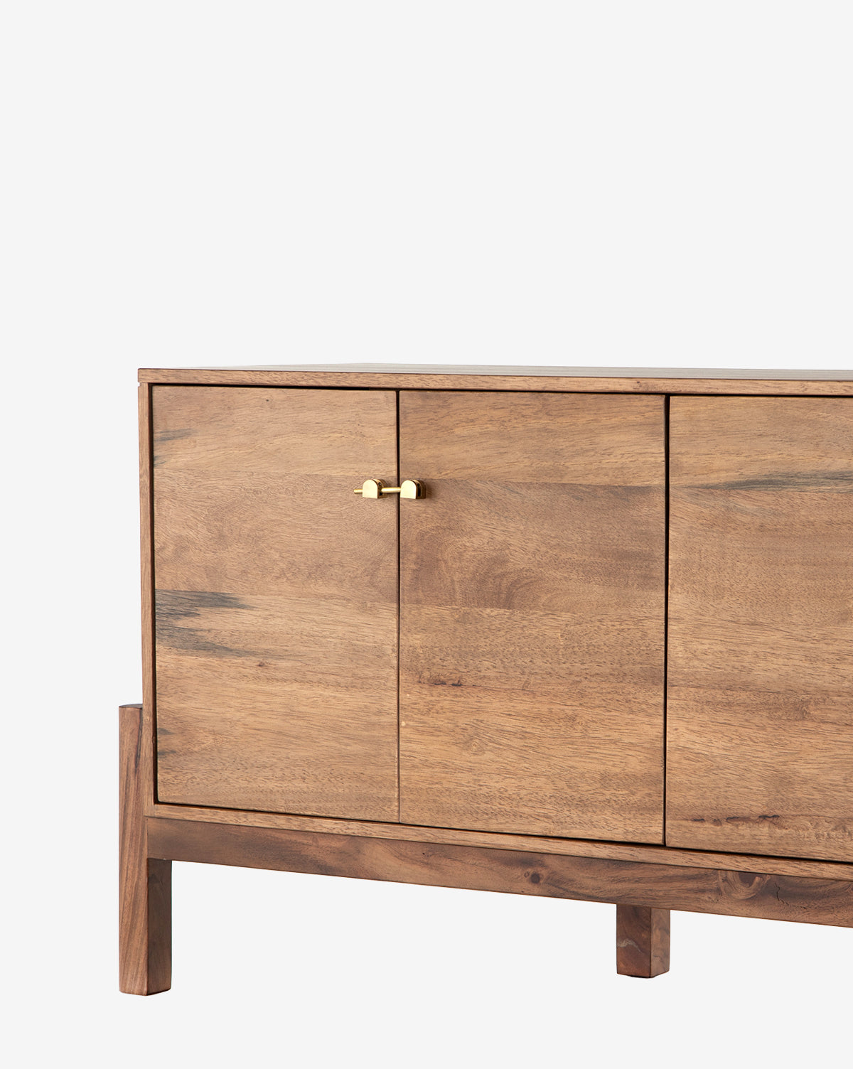 The Gustav Console is a natural-finish wooden sideboard with three doors, a small brass handle on the left door, four sturdy legs, and built-in media cord management—ideal as a mid-century console, by McGee & Co.