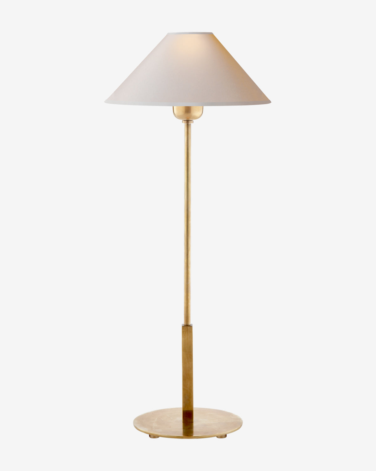 The Hackney Table Lamp features a slim brass body, a wide white linen shade, and stands on a round gold base, shown against a plain white background by McGee & Co.