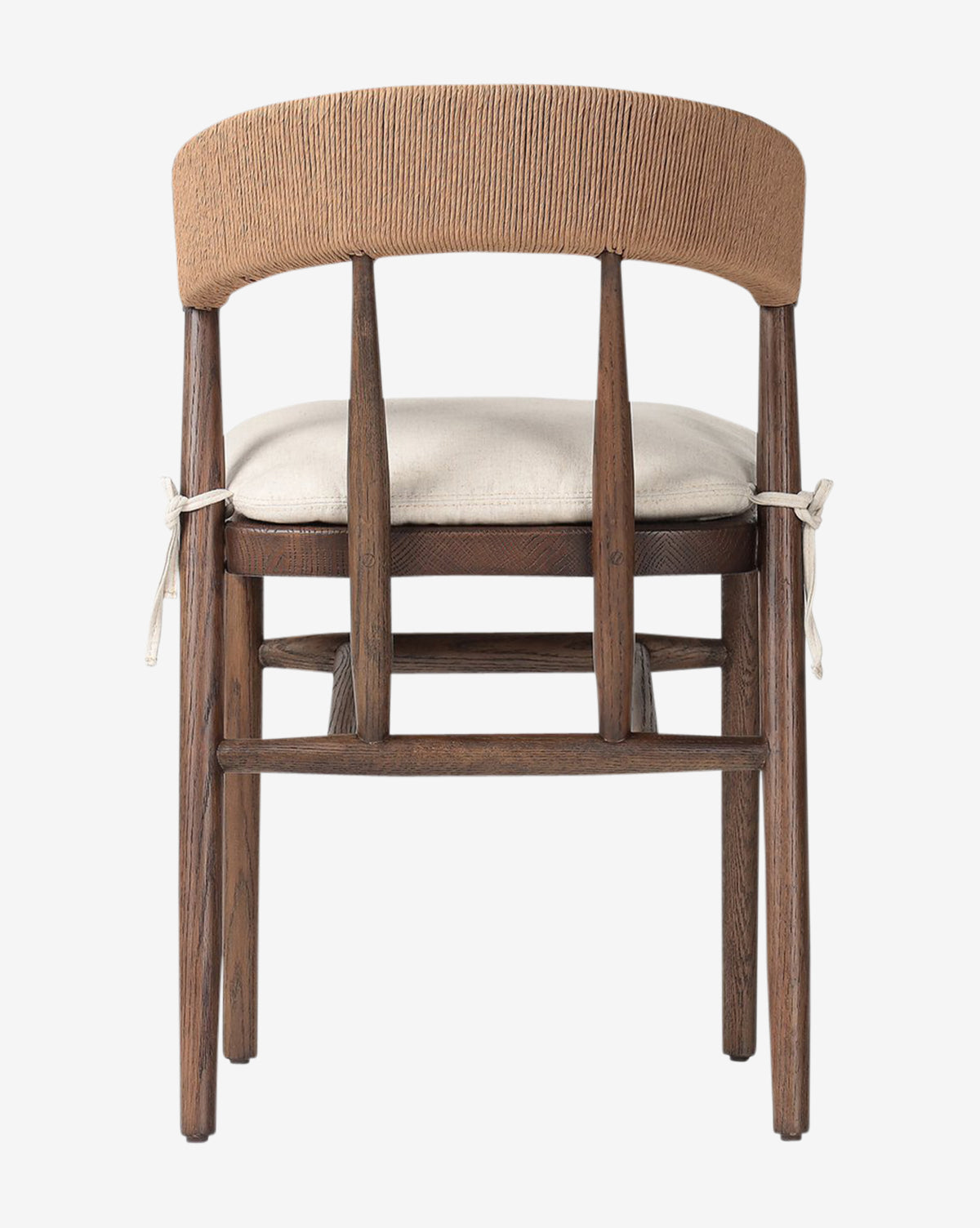 The Hallow Chair is a rustic dining chair with a curved, woven backrest and a light cushioned seat tied to its oak frame, shown from behind against a white background by McGee & Co.