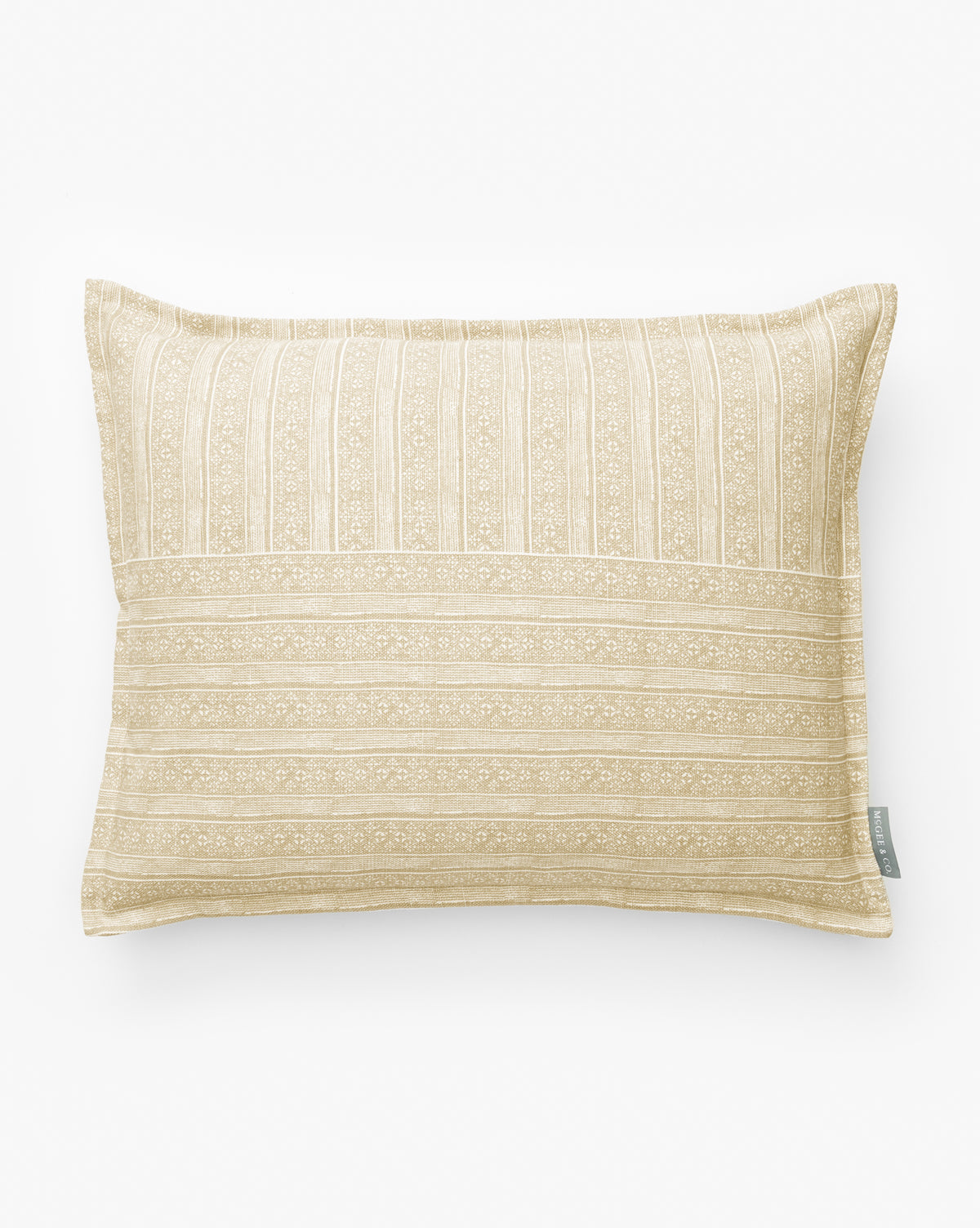 The Halstead Pillow Cover is a rectangular tan and white cover with subtle stripes and floral patterns, made from cotton and linen. It features a small fabric tag on the side and is shown against a plain white background by McGee & Co.