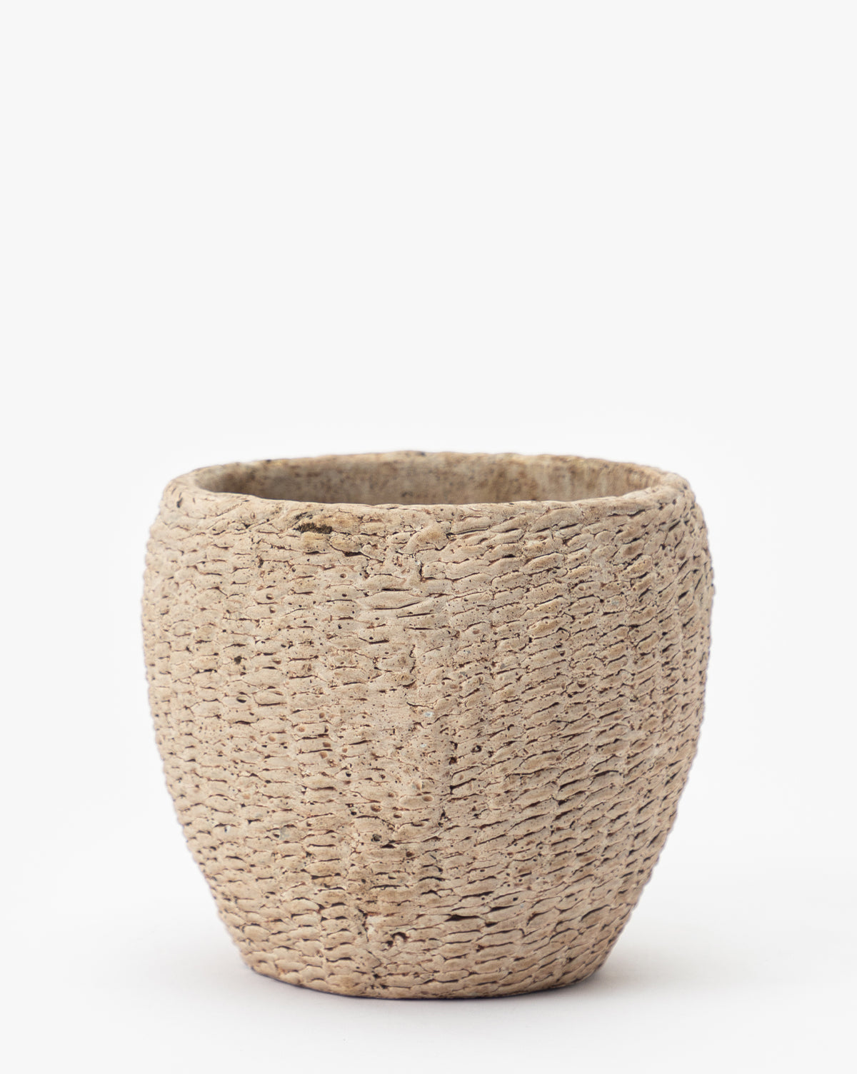 The Halston Cement Planter features a round, beige design with a textured, woven-like surface, displayed on a plain white background.