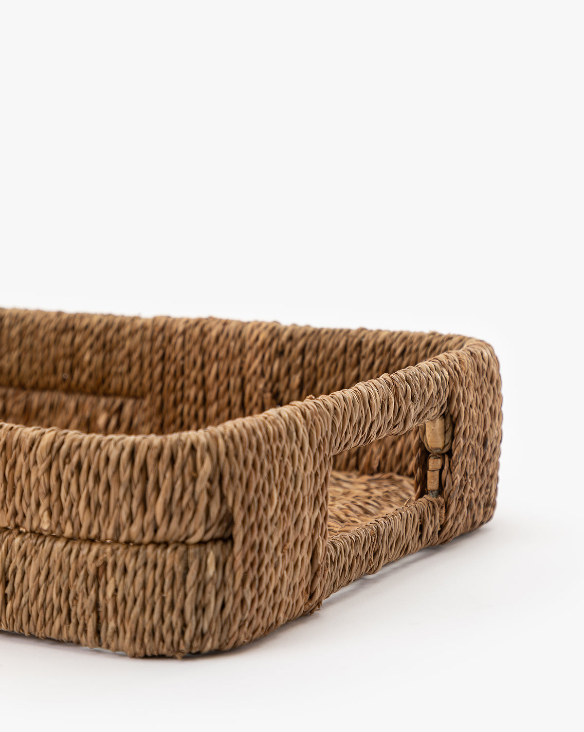 A close-up of the Hand-Woven Bankuan Tray, featuring built-in handles and its natural rectangular texture, displayed on a white background.