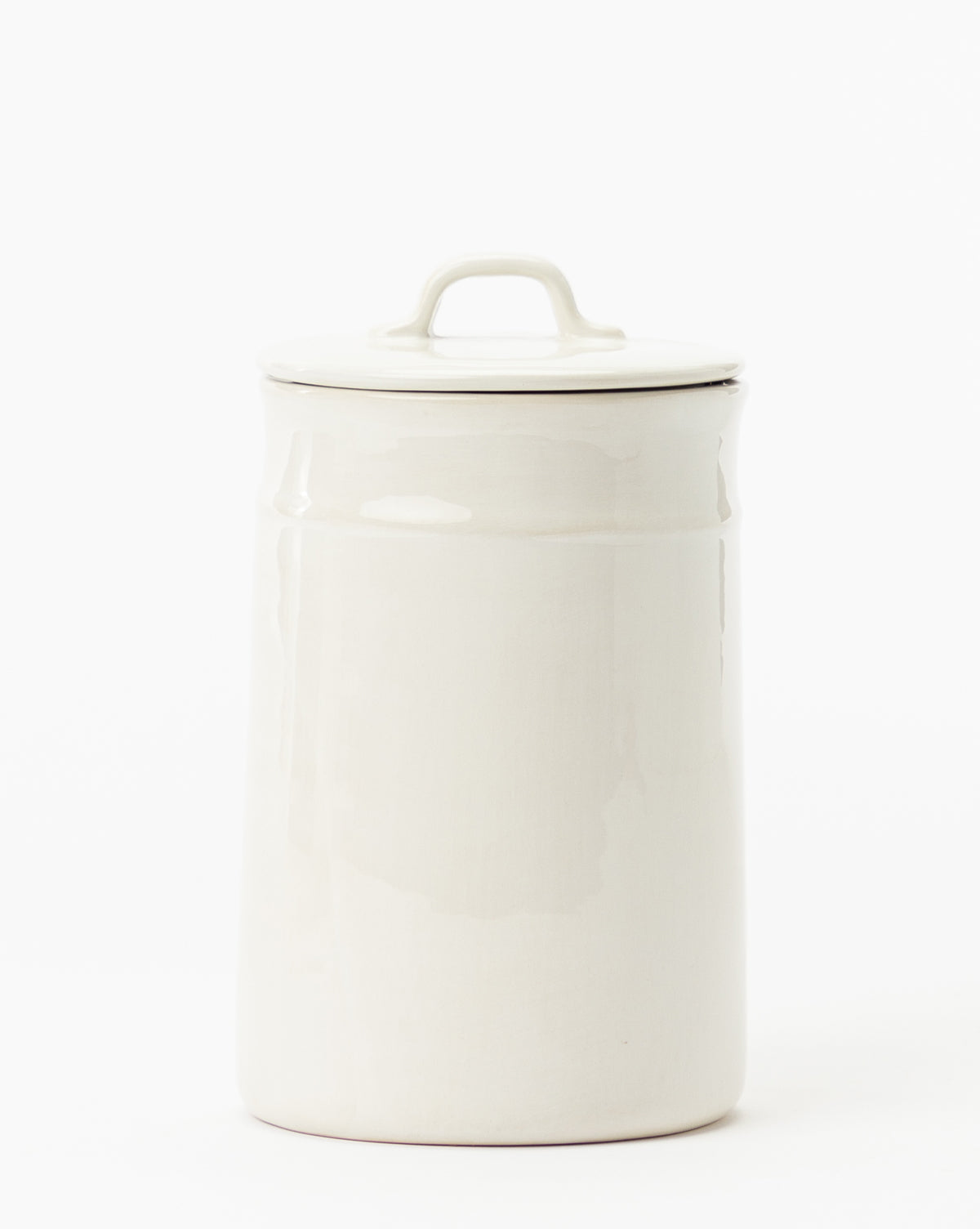 The Handled Ceramic Canister features a vintage-style design with a matching lid and top handle, making it a charming white accent for any modern kitchen. Set against a plain white background.