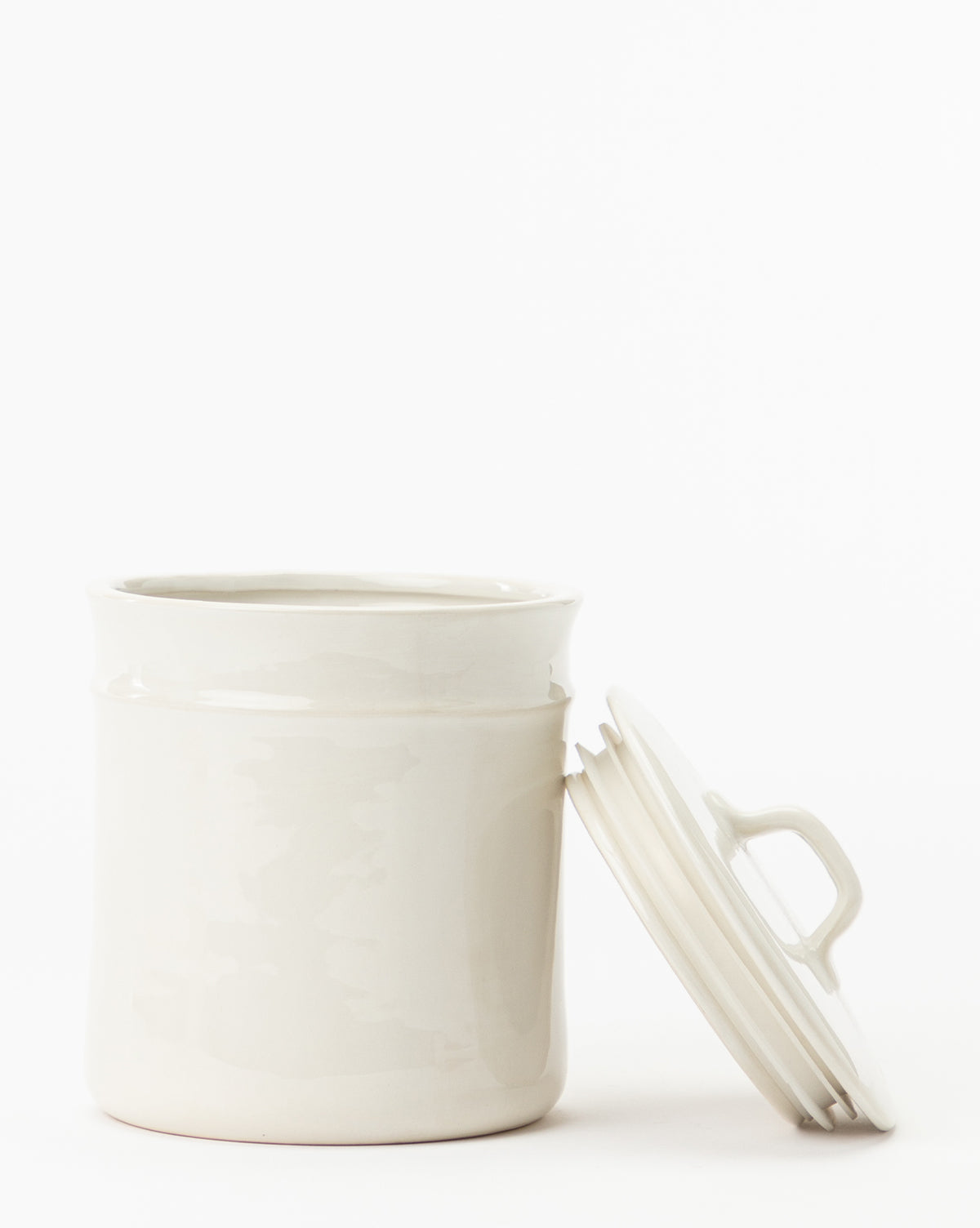 The Handled Ceramic Canister features a white handle and matching lid, showcased upright on a plain white background. Its simple, vintage-inspired style makes it perfect for any modern kitchen canister collection.
