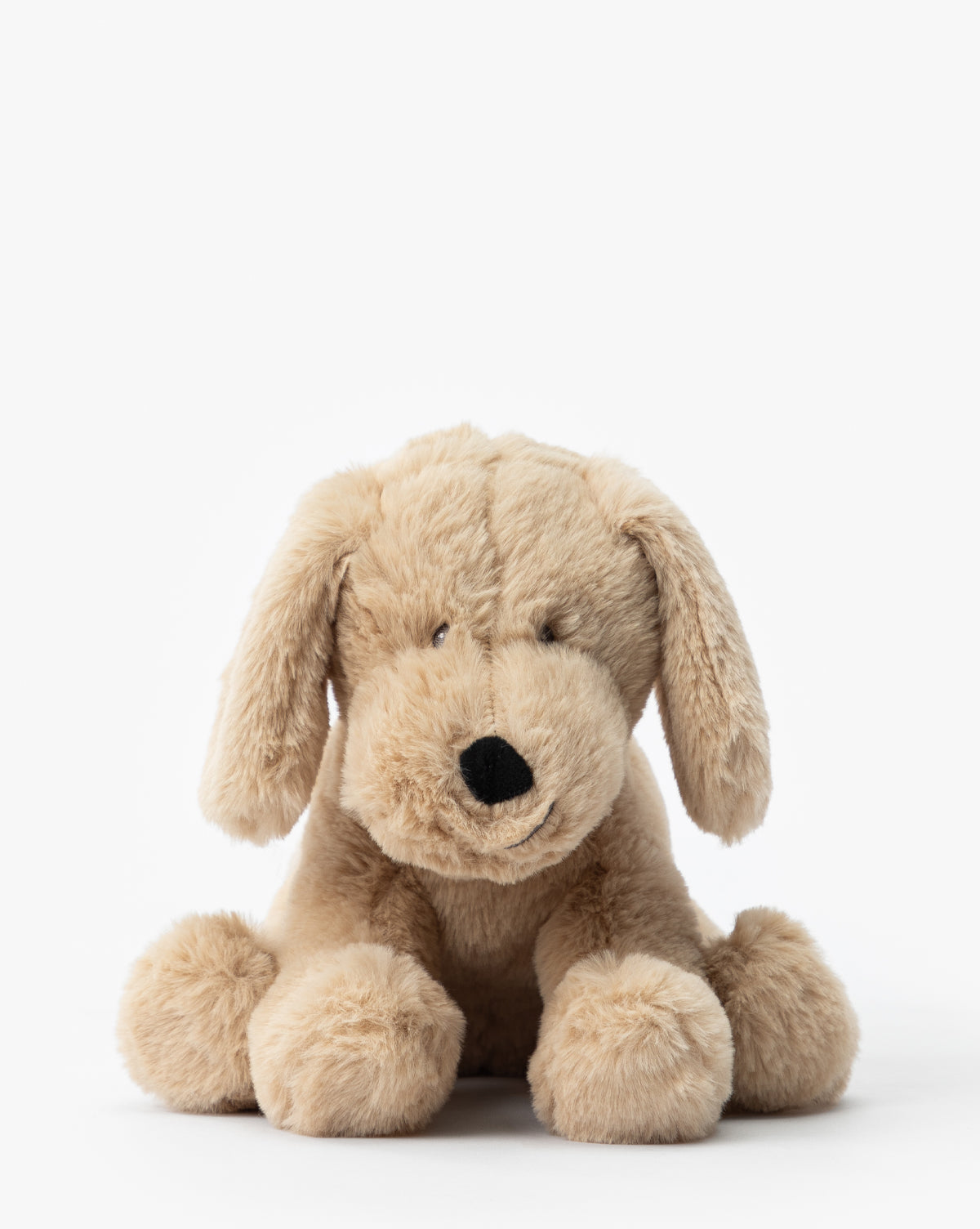The Hank Plush Pup is a soft, light brown stuffed dog with floppy ears and a black nose. It sits facing forward on a white background—an adorable addition to any childrens room or nursery, by McGee & Co.