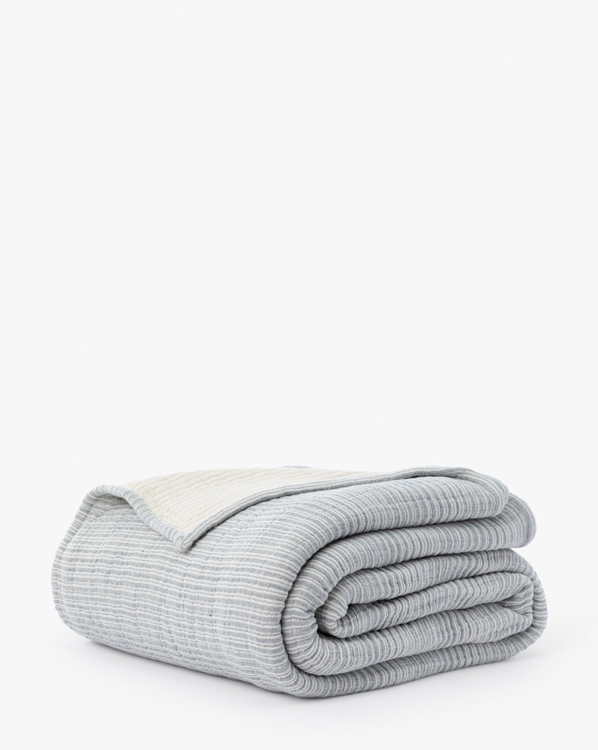 The Hanson Striped Cotton Coverlet, in light gray with subtle horizontal stripes and a lighter edge, is neatly folded on a white background—ideal for accenting neutral bedding styles.