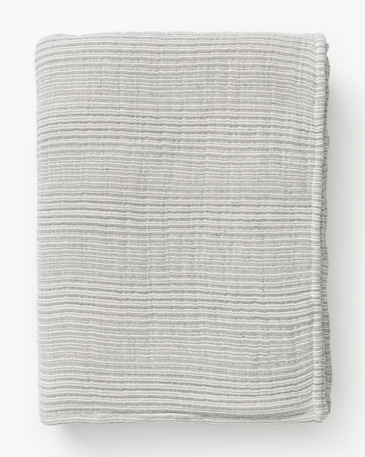 The Hanson Striped Cotton Coverlet features a neatly folded, light gray striped design with subtle horizontal texture—ideal for adding a touch of neutral style to your favorite bedding. Displayed on a white background.
