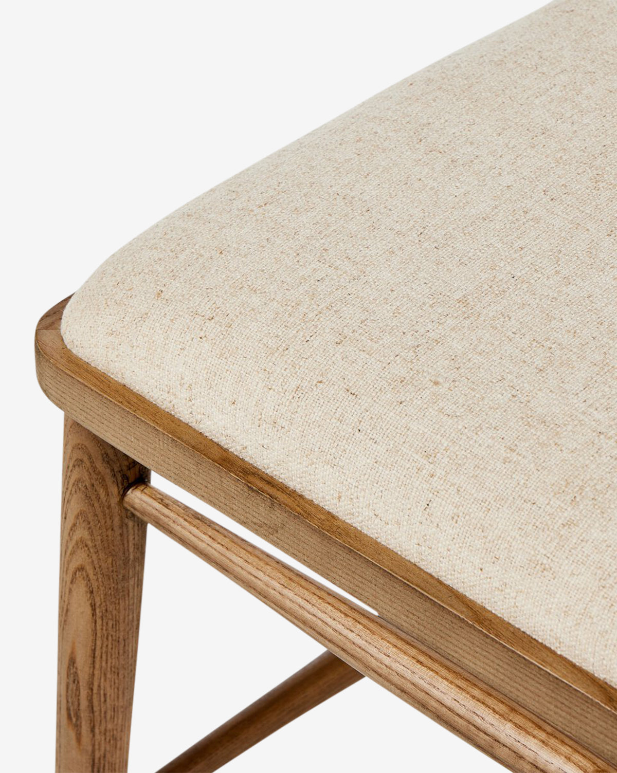 Close-up of the Harper Dining Chair, made from solid ash with a light beige upholstered seat cushion. The image showcases its smooth wood grain and modern design against a white background, by McGee & Co.