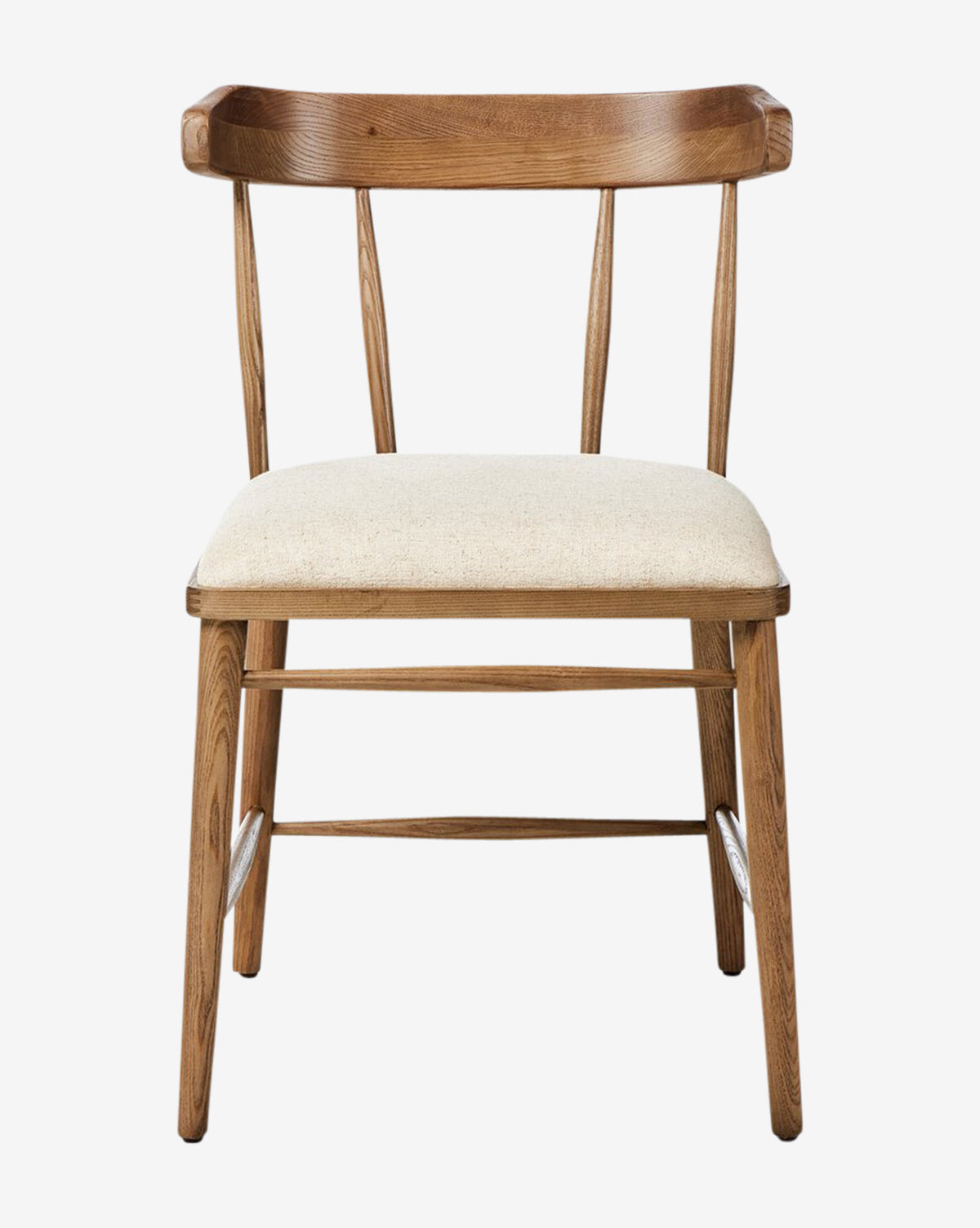 The Harper Dining Chair, shown against a plain white background, features solid ash construction with angled legs, a curved backrest with vertical spindles, and a light beige upholstered seat cushion by McGee & Co.
