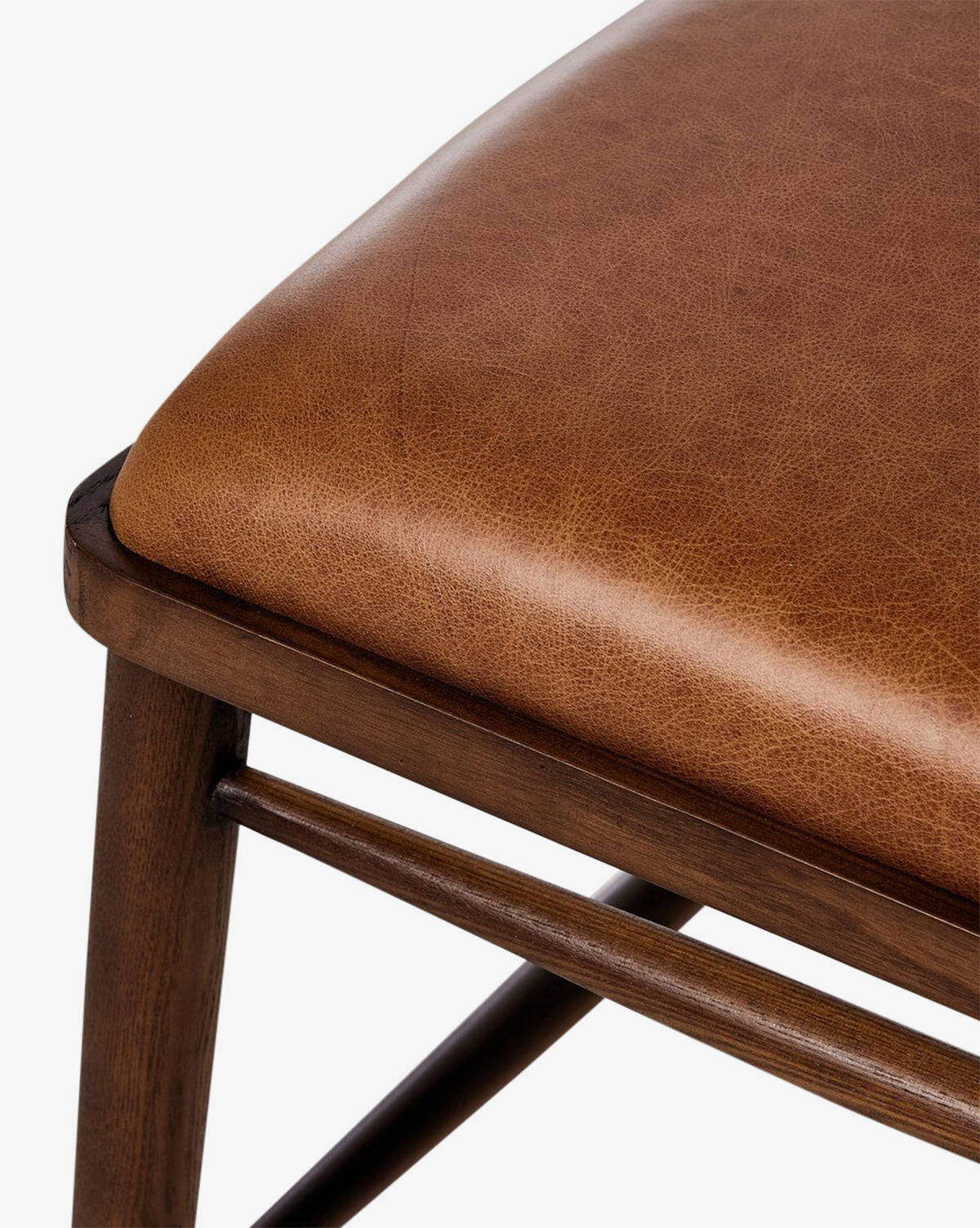 Close-up of the Harper Dining Chair’s brown upholstered seat with visible stitching and a sturdy ash wood frame, shown against a white background by McGee & Co.