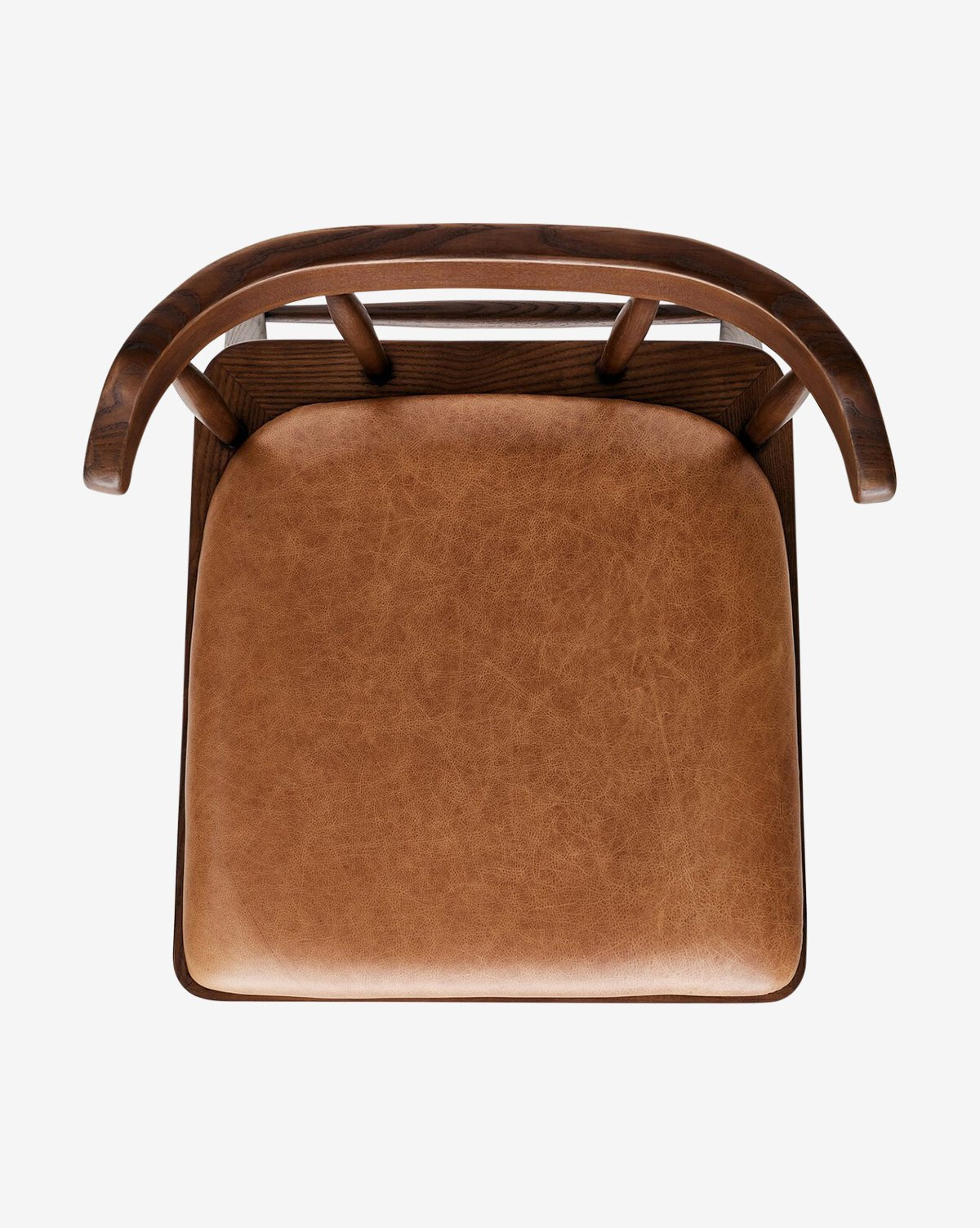 Top-down view of the Harper Dining Chair, showcasing its curved backrest and upholstered tan leather seat, crafted from solid ash wood, set on a white background, by McGee & Co.