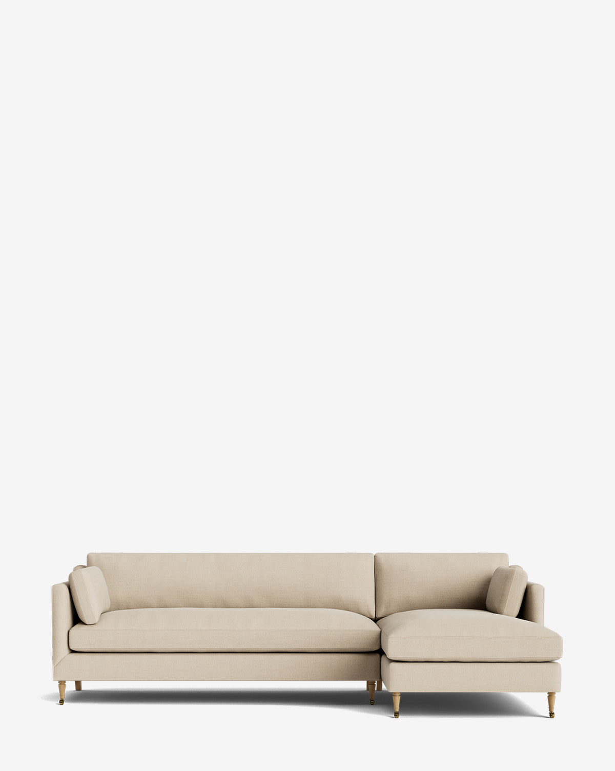 The Haverford Upholstered Right Chaise Sectional by Rowe Fine Furniture features a beige finish, low backrests, two matching cylindrical pillows, and wooden legs with brass accents, shown against a plain white background by McGee & Co.