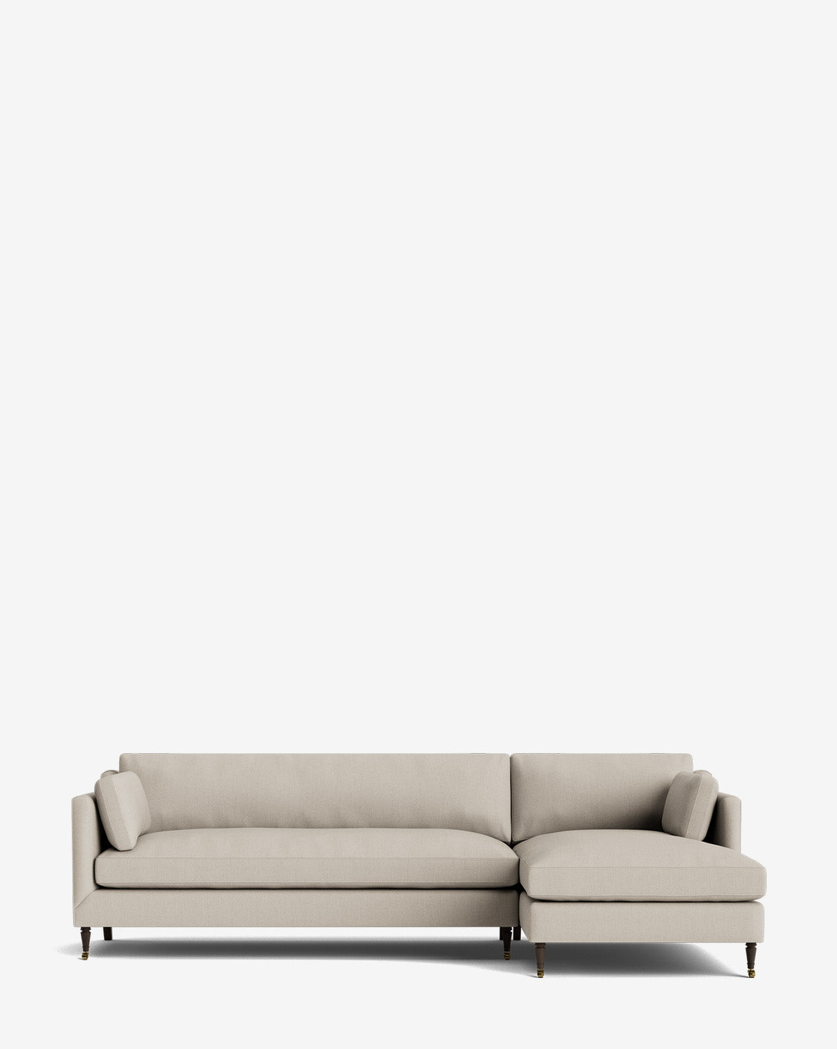 A light beige Haverford Upholstered Right Chaise Sectional 113 with slim armrests, two matching bolster pillows, and wooden legs is shown against a plain white background, by McGee & Co.